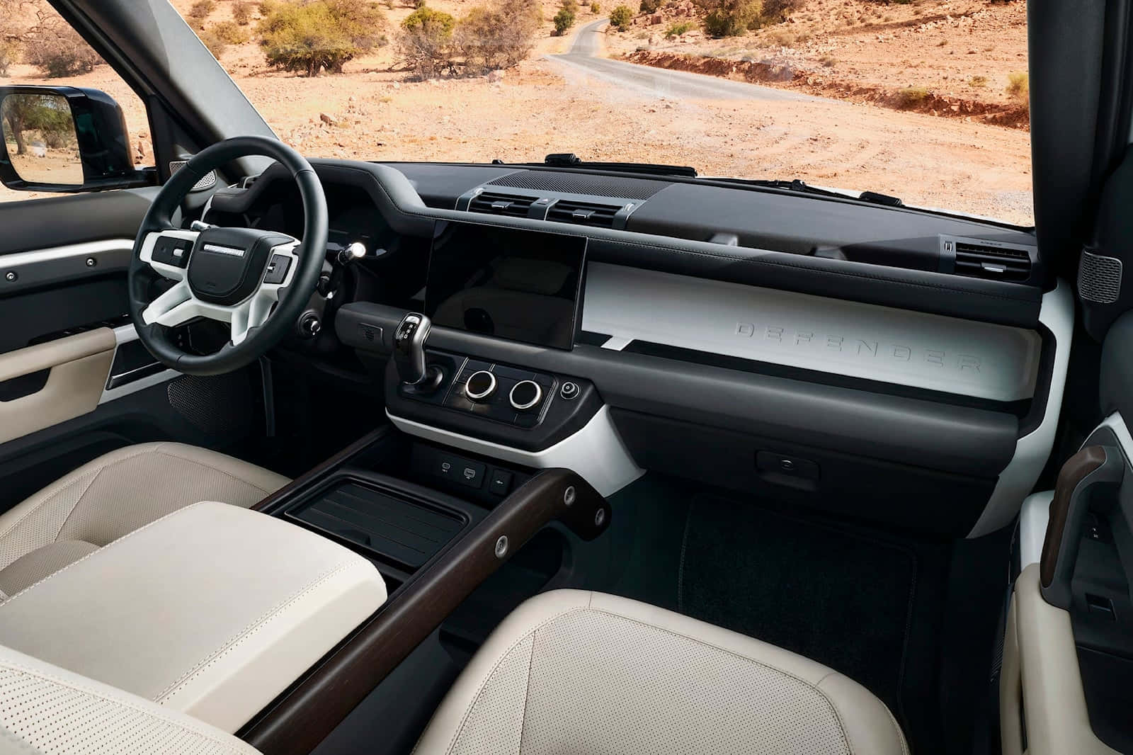 Land Rover Defender 桌布 壁紙 — 豪華SUV內裝，配以奶油色皮革座椅和木飾，俯瞰沙漠道路。