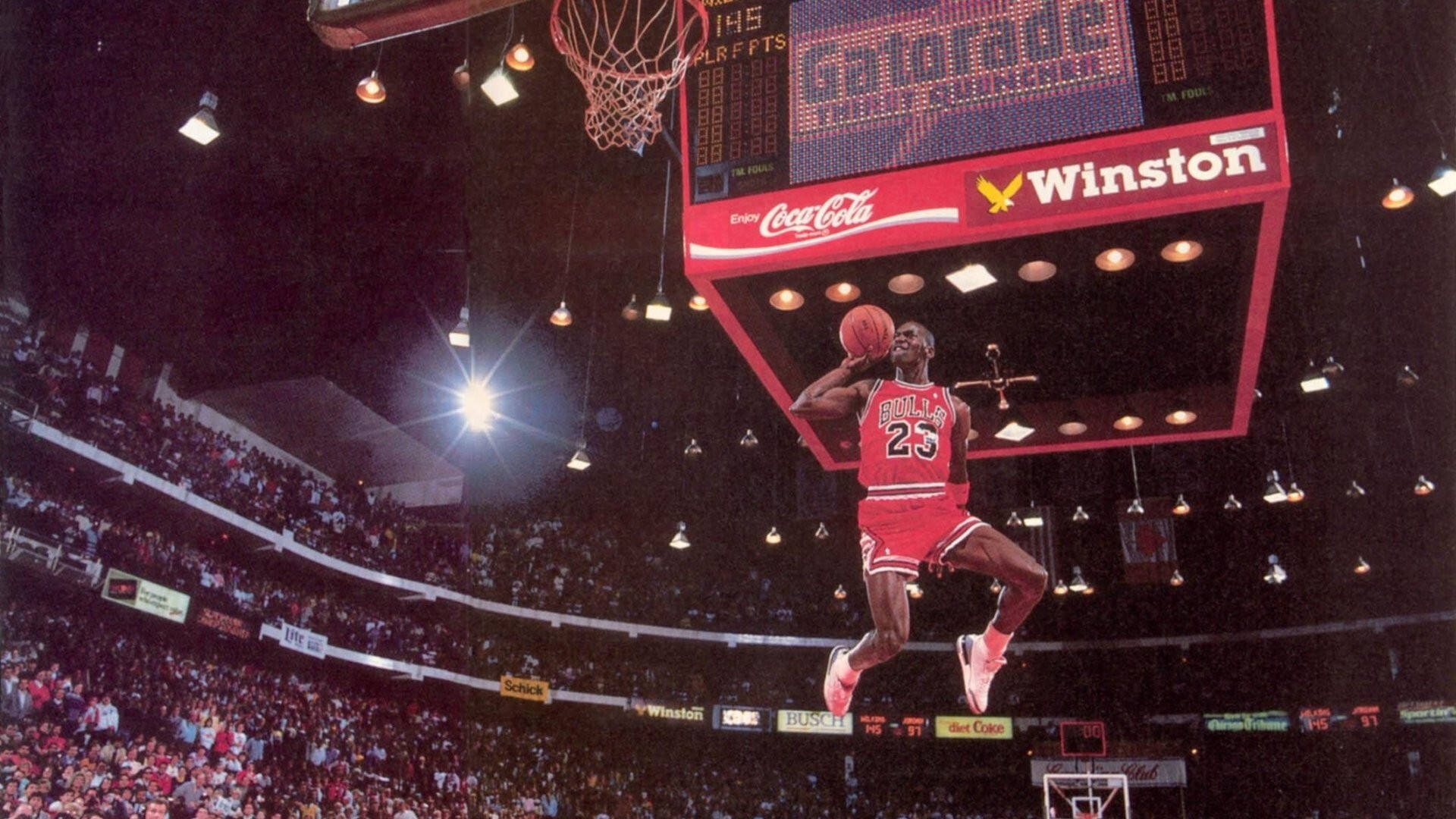 麥可喬丹在擠滿觀眾的場館中空中灌籃。 — Air Jordan 壁紙