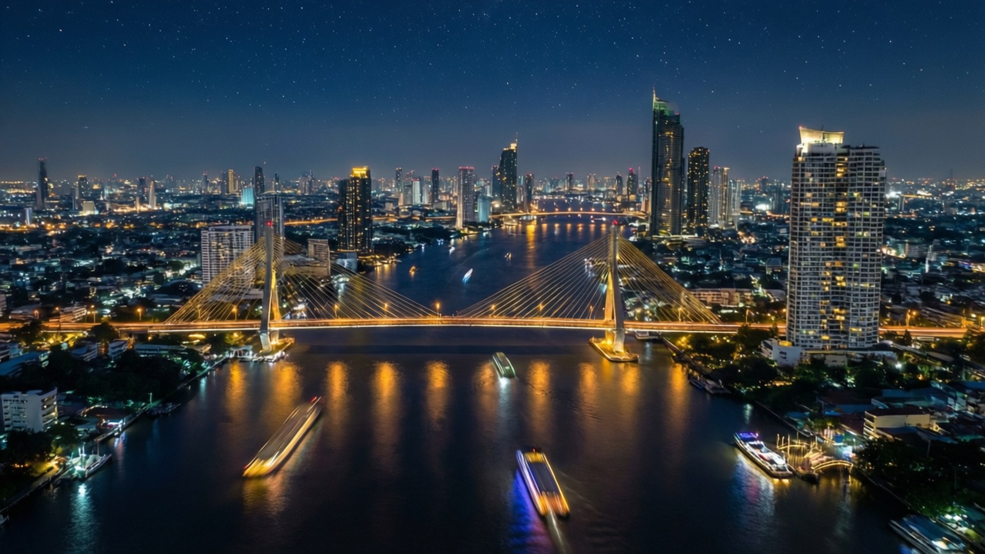 Bangkok River of Lights 壁紙 — 曼谷天際線的夜間空中景觀，一座發光的斜張橋橫跨滿載移動船隻的河流，星空下。