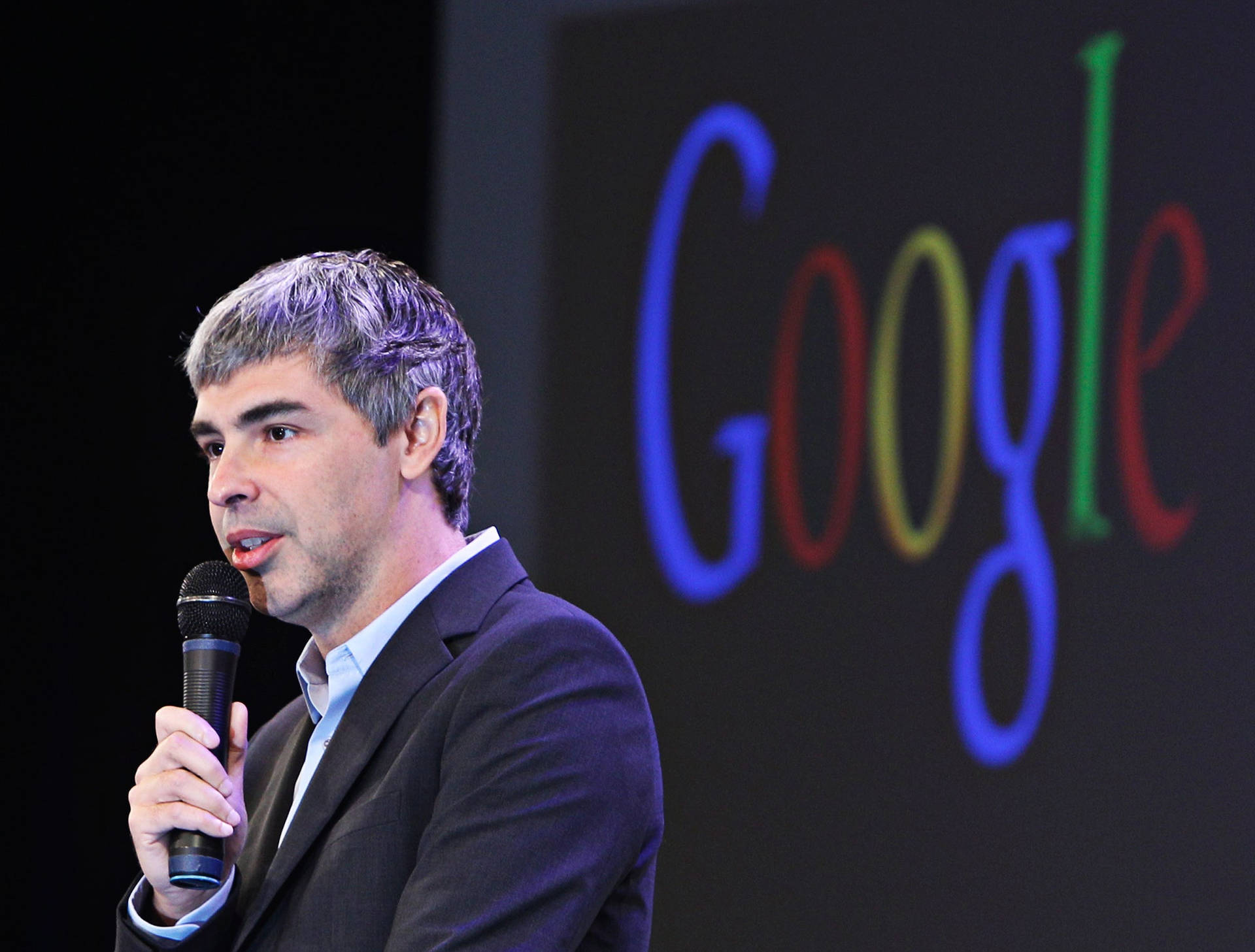 男子在Google活動中對著麥克風講話 — Google 壁紙