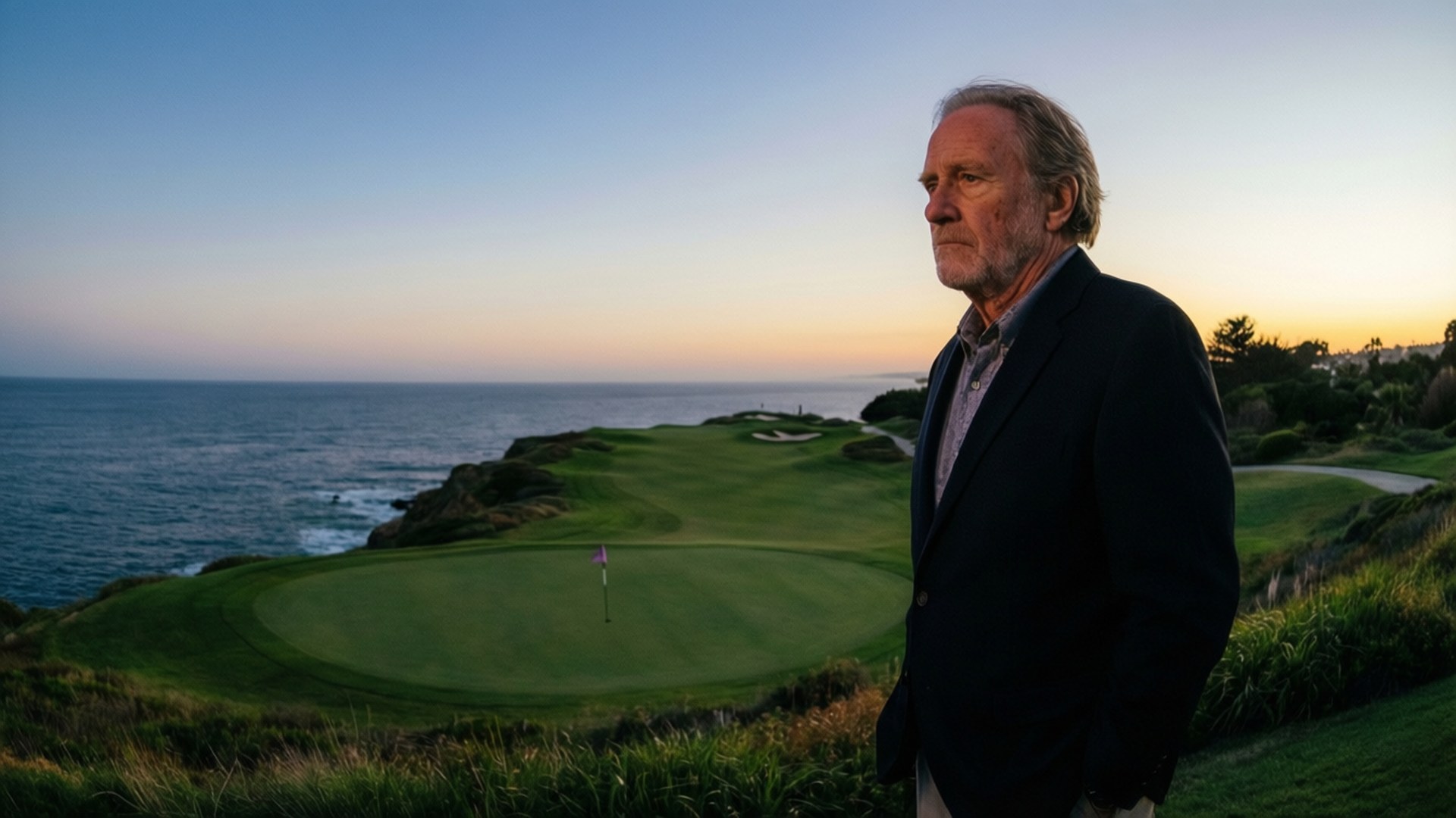 Sunset Over Ocean Course 壁紙 — 一名身穿深色夾克的男子站在懸崖邊的高爾夫球場上，俯瞰日落時分的海洋。