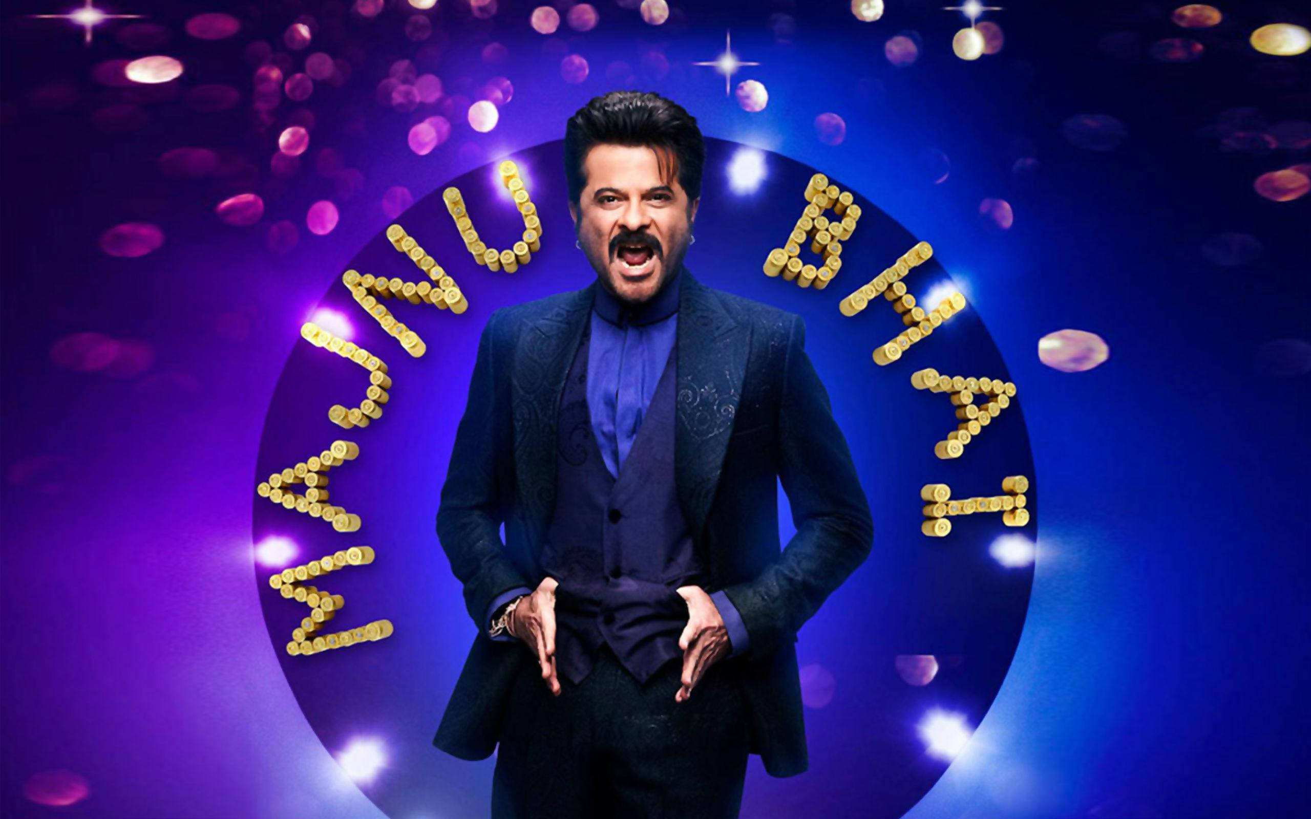 anil kapoor 桌布 壁紙 — Manju Bhati 自信地站在深色西裝中，背景是充滿活力的紫色，發光的金幣拼出他的名字。