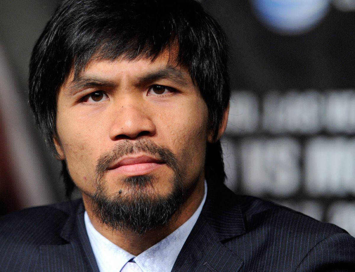 Pacman 桌布 壁紙 — Manny Pacquiao 身穿深色西裝、表情嚴肅的特寫肖像，背景模糊。