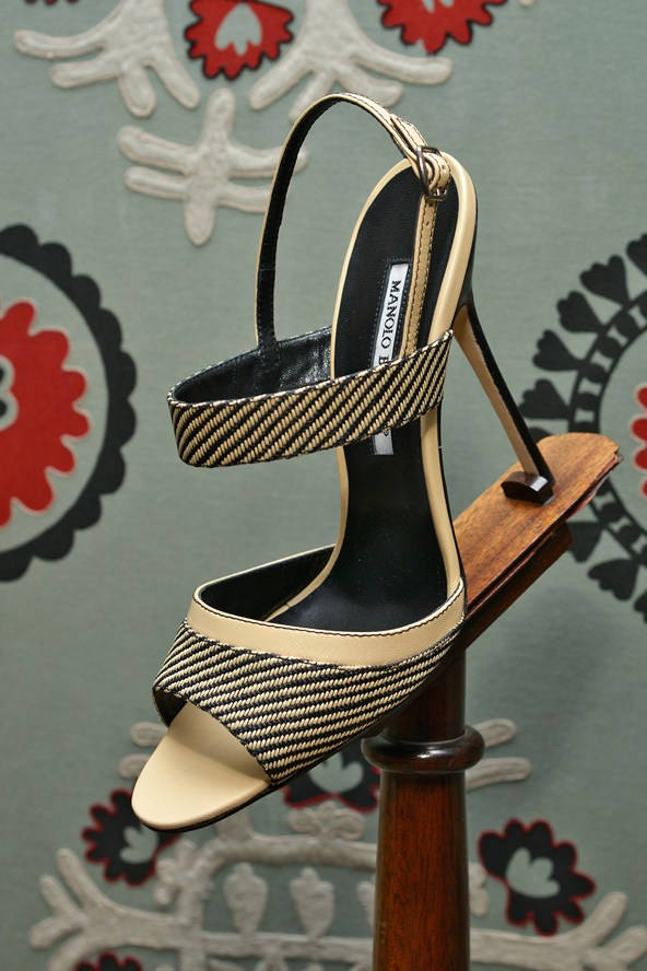 鞋子 桌布 壁紙 — Manolo Blahnik 的米色和黑色條紋高跟涼鞋，展示在木架上，背景為圖案壁紙。