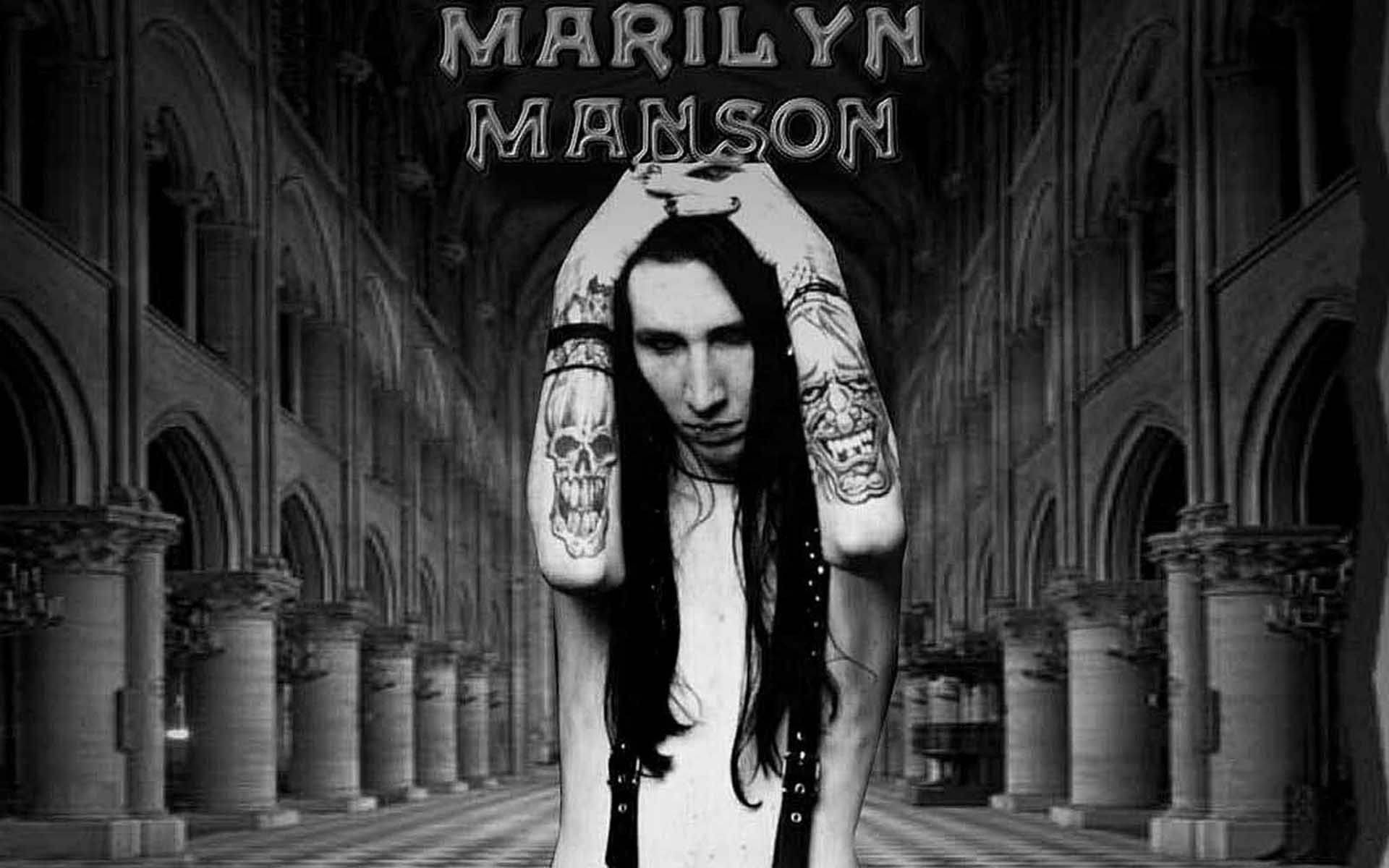 哥德式動圖 桌布 壁紙 — Marilyn Manson 站在哥德式大教堂的走廊上，手臂上有骷髏紋身，雙手在頭頂合攏，黑白肖像。
