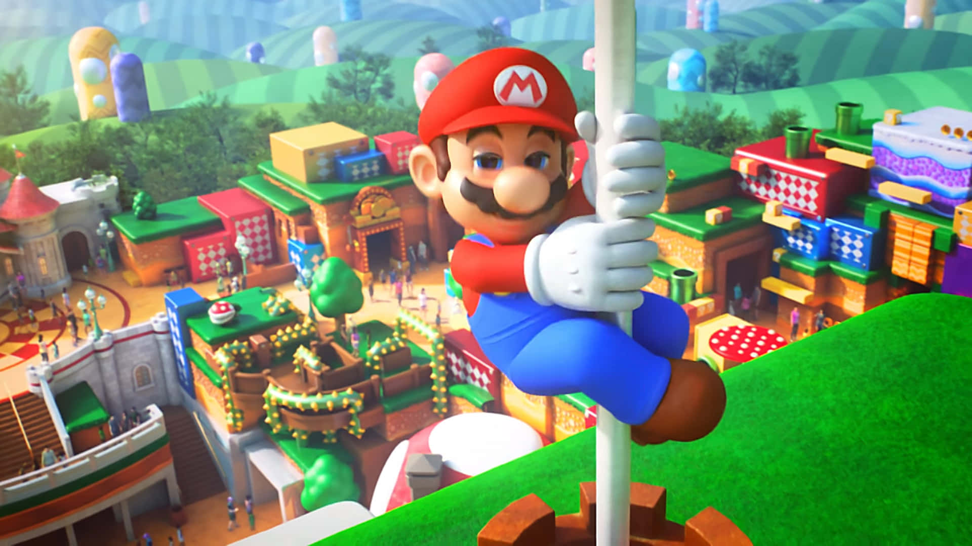 Mushroom Kingdom 桌布 壁紙 — Mario 爬上一根柱子，下方是色彩繽紛的 3D 渲染小鎮，有糖果般的建築和綠色山丘。
