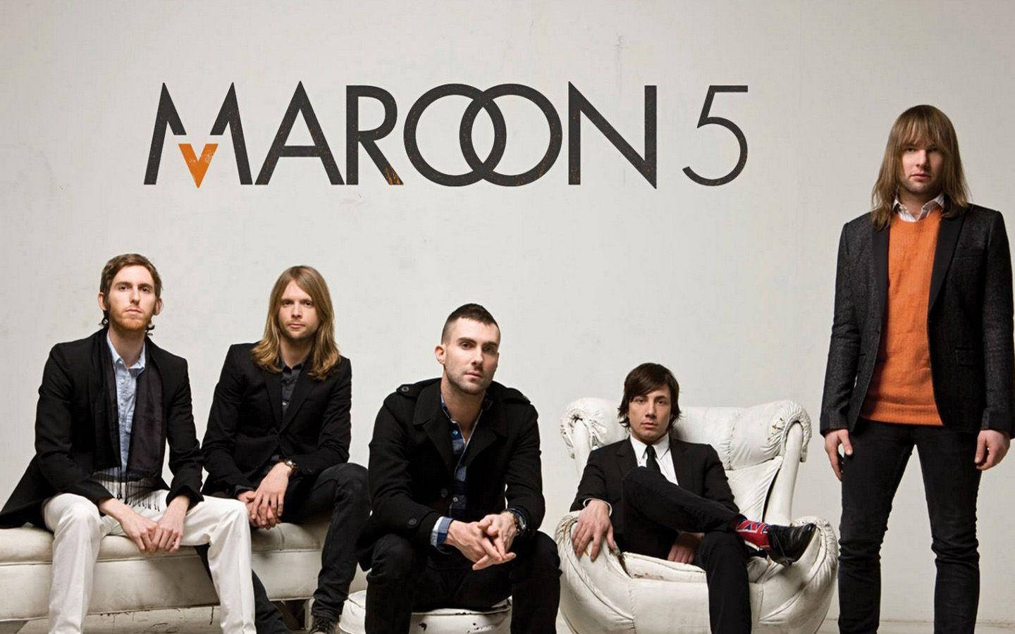 標誌 桌布 壁紙 — Maroon 5 樂團成員自信地穿著黑色西裝和橙色點綴，在極簡白色牆壁前與他們的標誌合影。