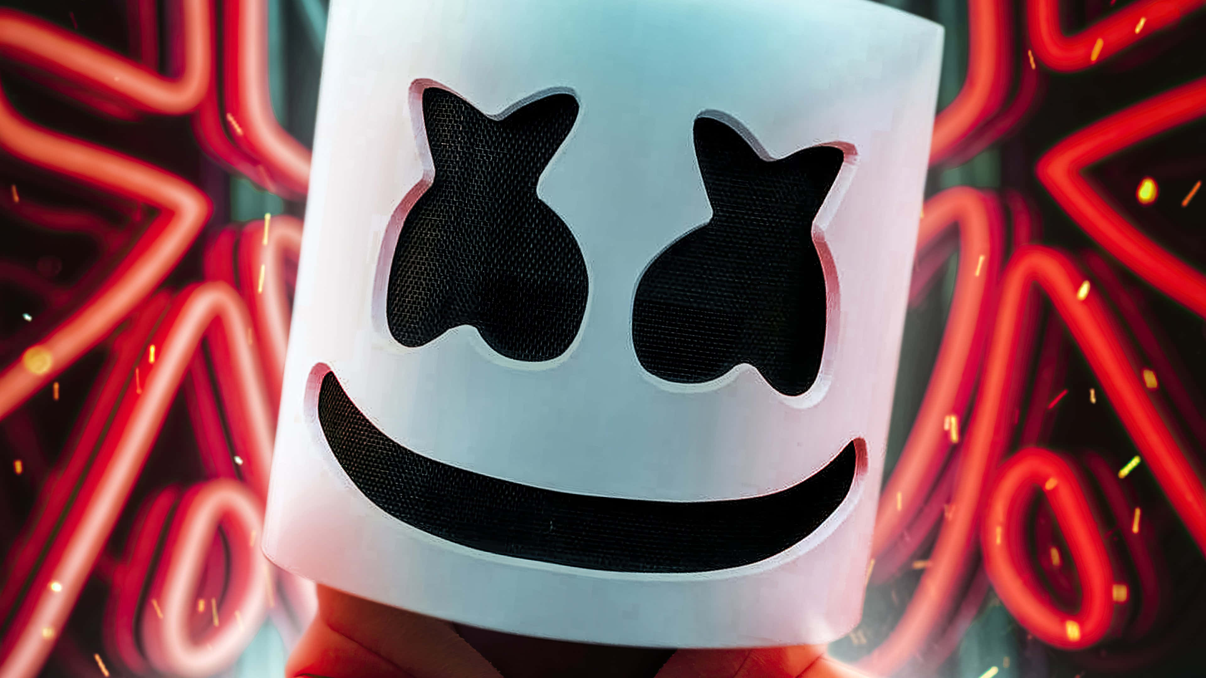 Marshmello 動態圖 桌布 壁紙 — Marshmello 標誌性白色頭盔的特寫，帶有黑色網眼眼睛和微笑，背景是充滿活力的紅色霓虹燈和火花。