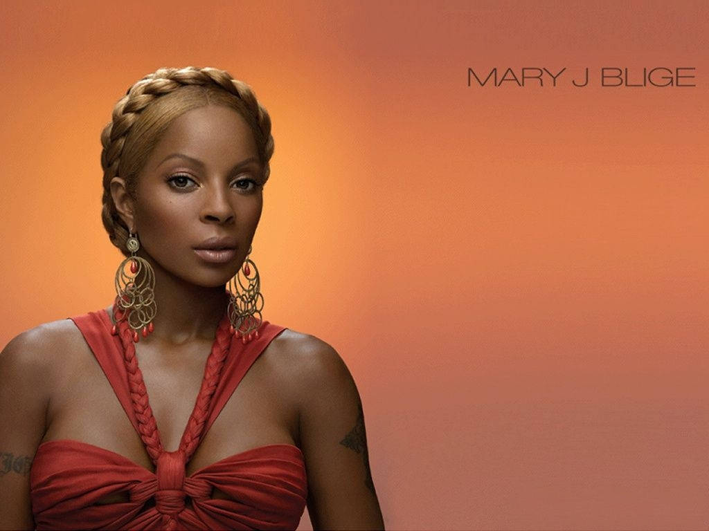 音樂 桌布 壁紙 — Mary J Blige 在溫暖的橙色漸變背景前，穿著紅色辮子裙擺姿勢，她的名字以文字顯示。