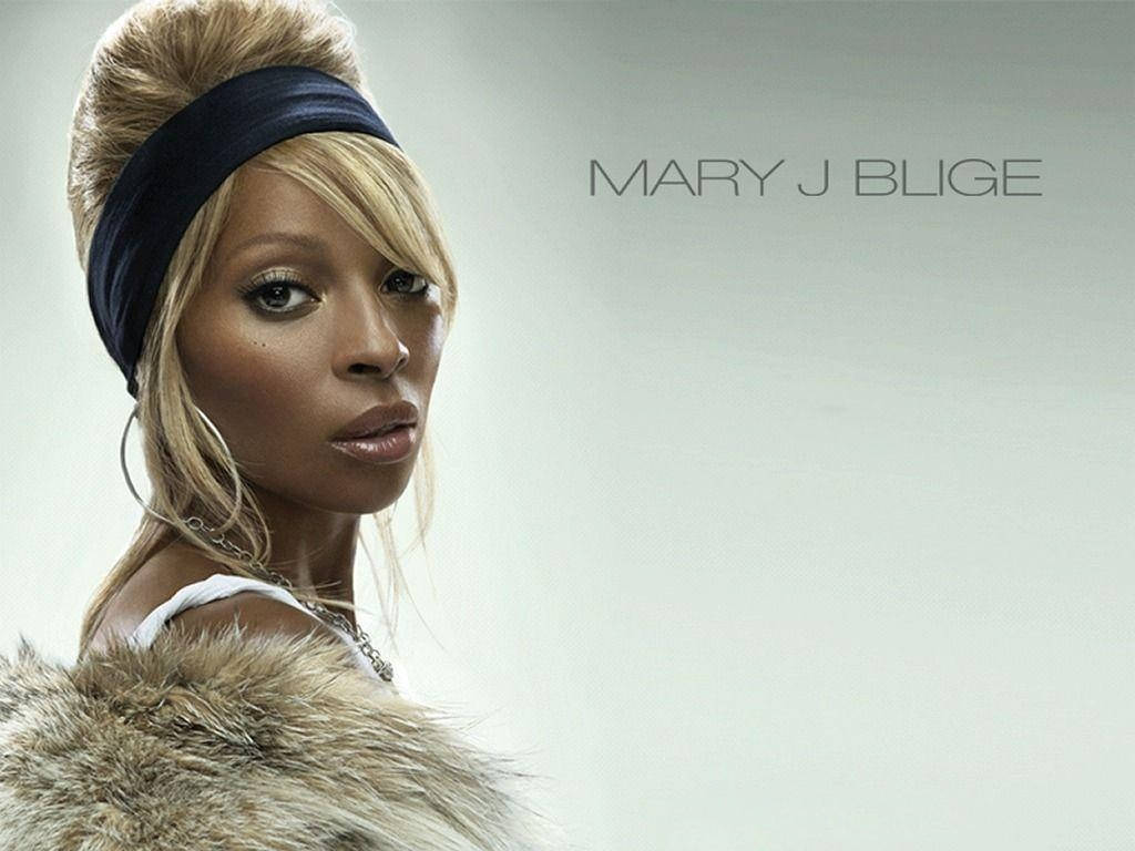音樂 桌布 壁紙 — Mary J Blige 專注地凝視，毛皮修飾的肩膀在純灰色背景上清晰可見。
