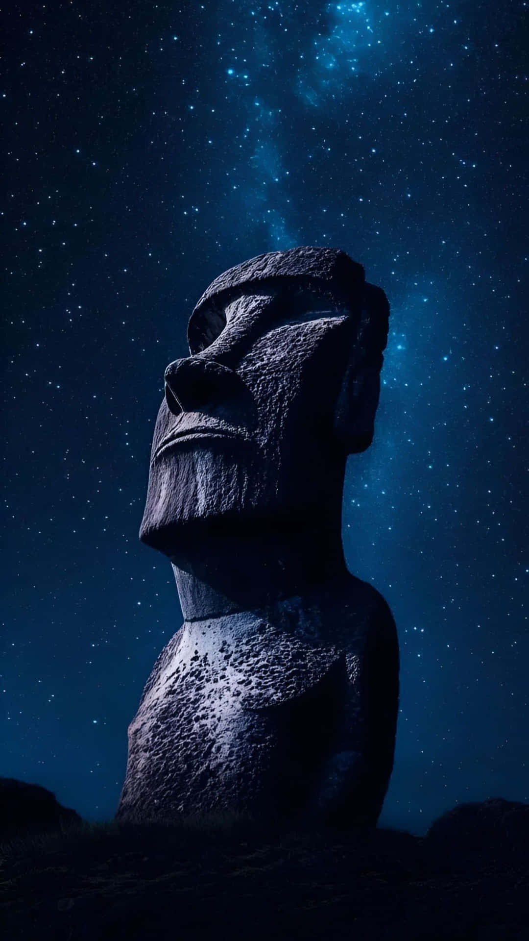  壁紙 — 一個巨大的石頭摩艾雕像在充滿星光的夜空下莊嚴地矗立，閃爍著宇宙塵埃的光芒。