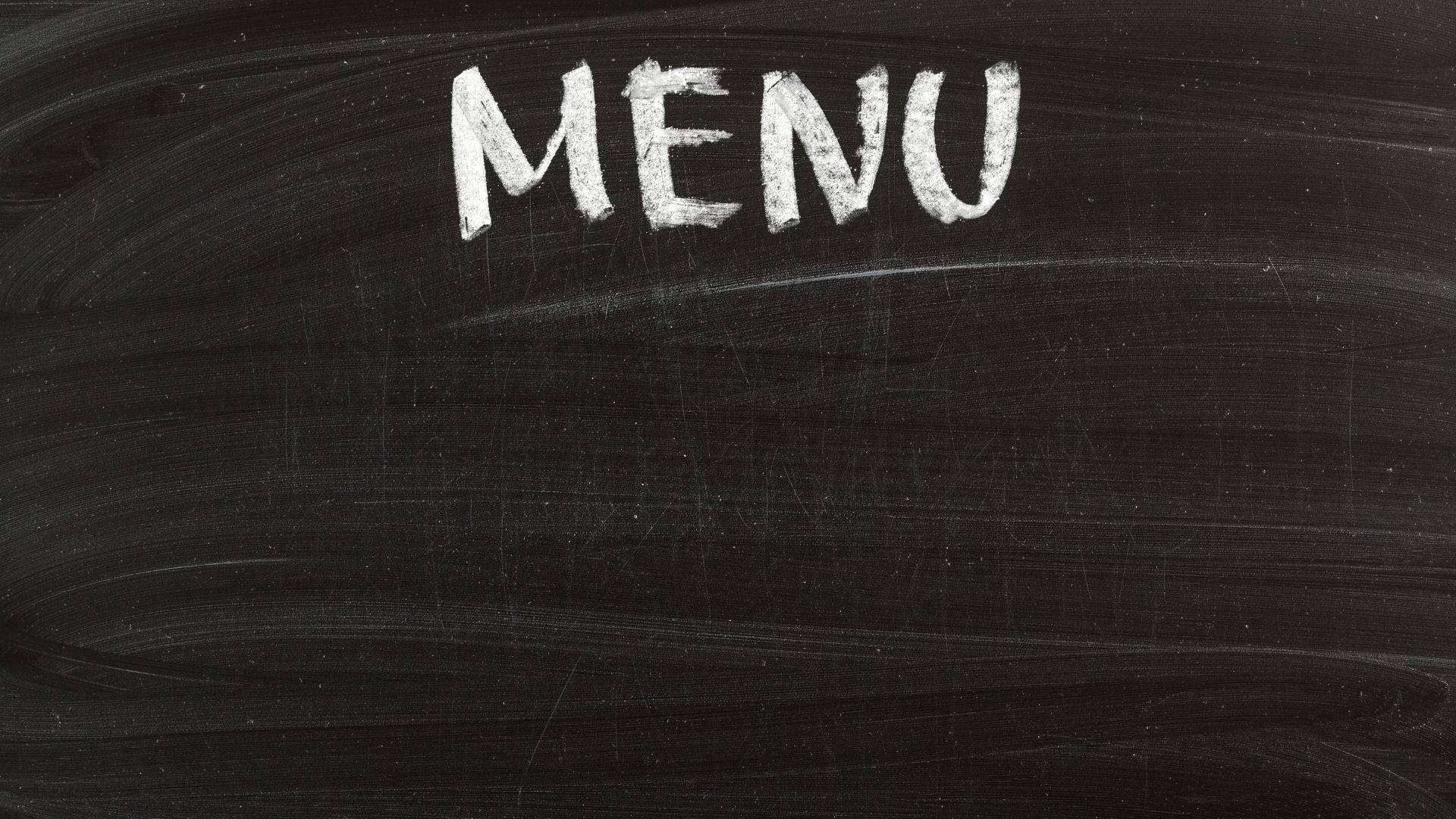 Restaurant 桌布 壁紙 — 「MENU」這個詞用粗體白色粉筆寫在有紋理的黑板上，有明顯的污跡和刮痕。