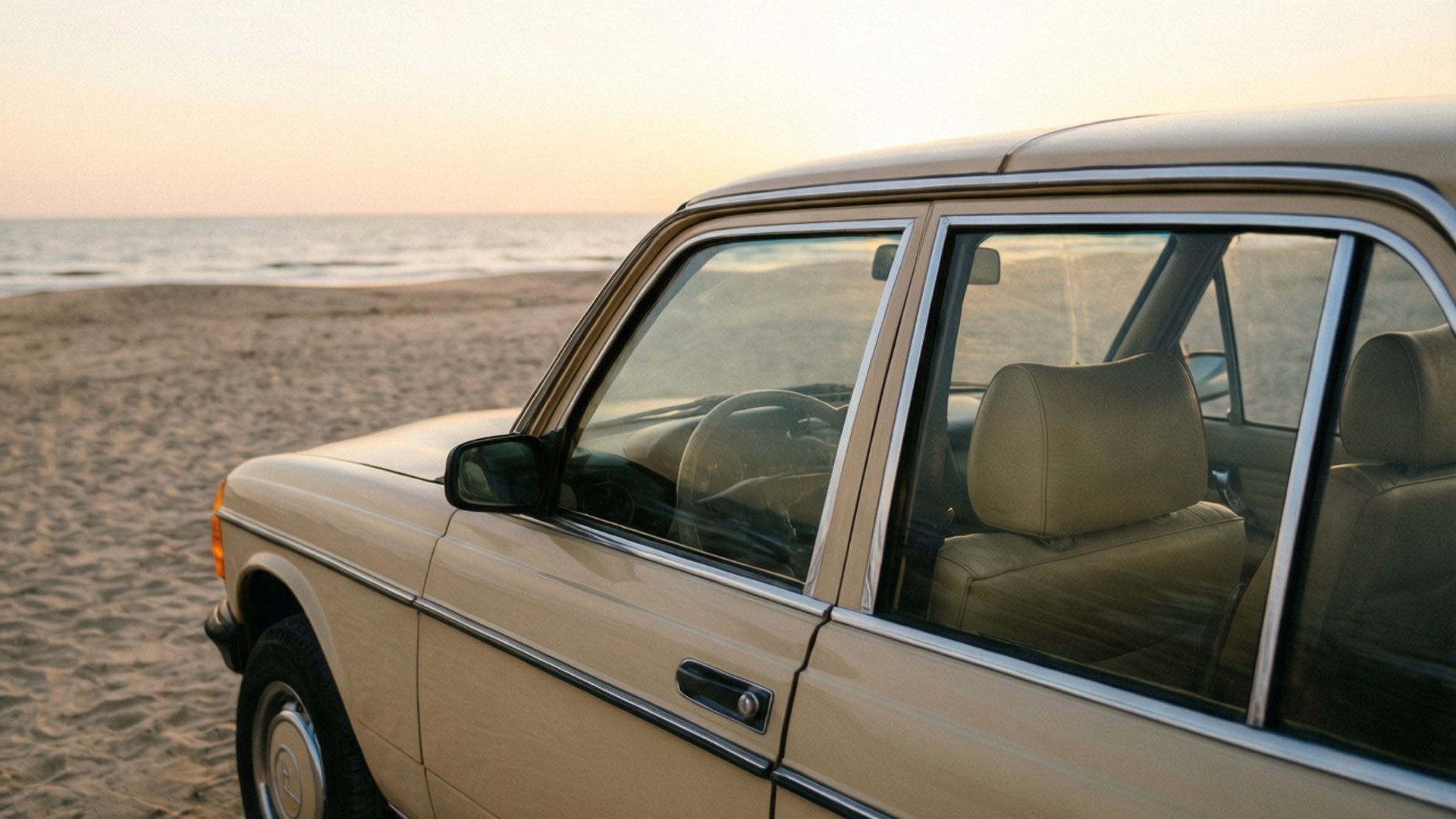 Beach Beige Vintage Car 壁紙 — 一輛米色復古車停在沙灘上，背景是日落和海洋波浪。