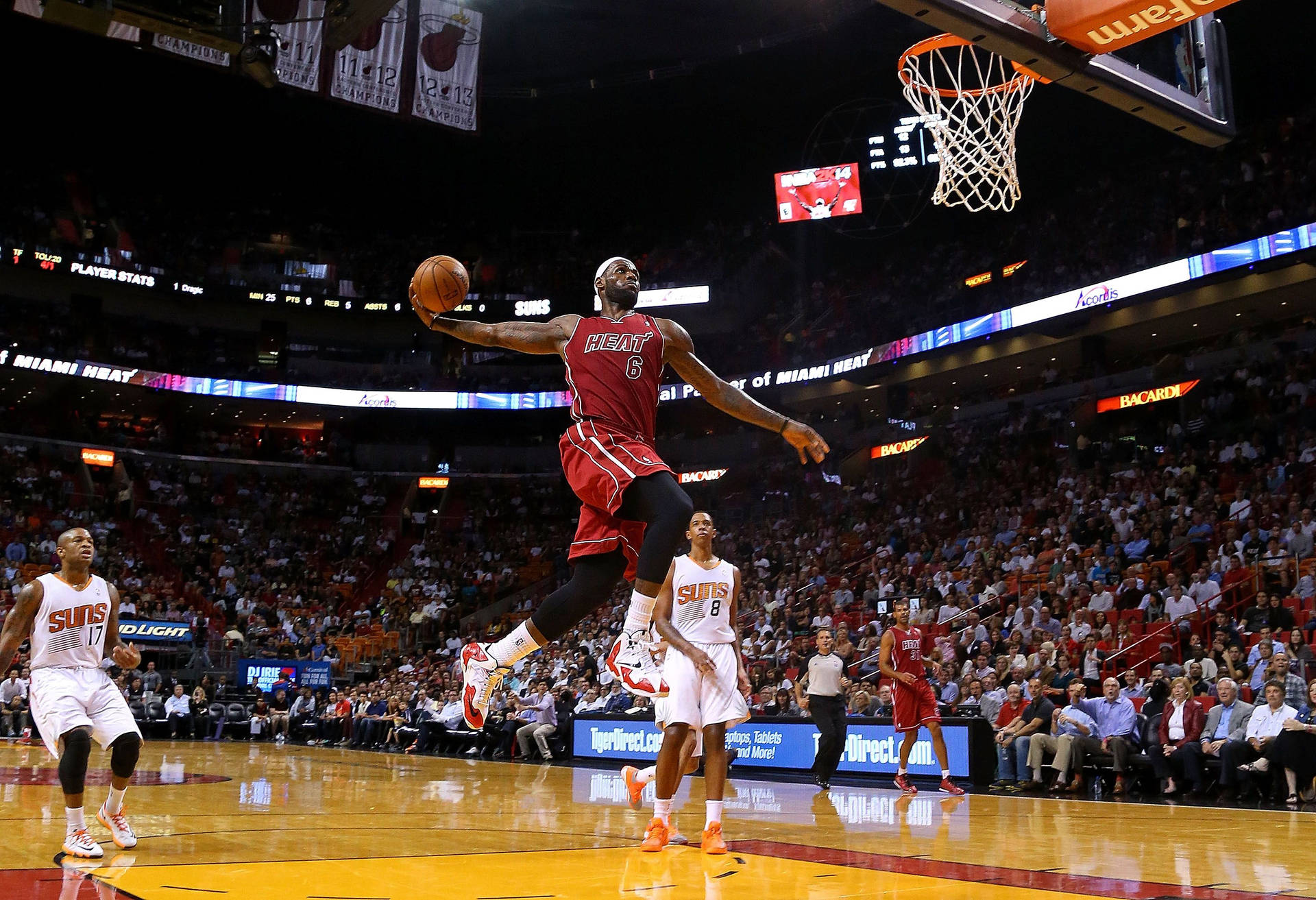 職業籃球運動員在現場比賽中空中灌籃，觀眾歡呼。 — NBA 壁紙