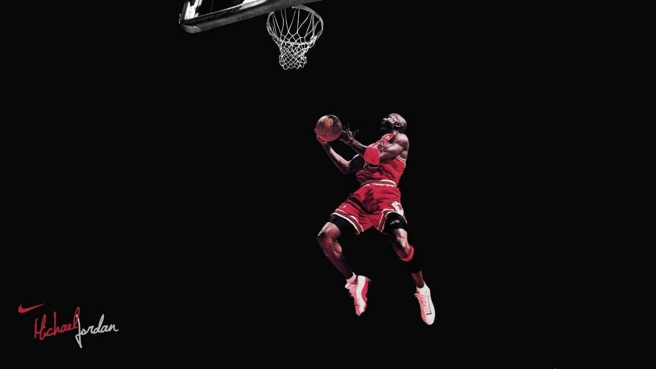 麥可喬丹在空中身穿紅色球衣，在黑色背景前灌籃。 — Jordan Logo 壁紙