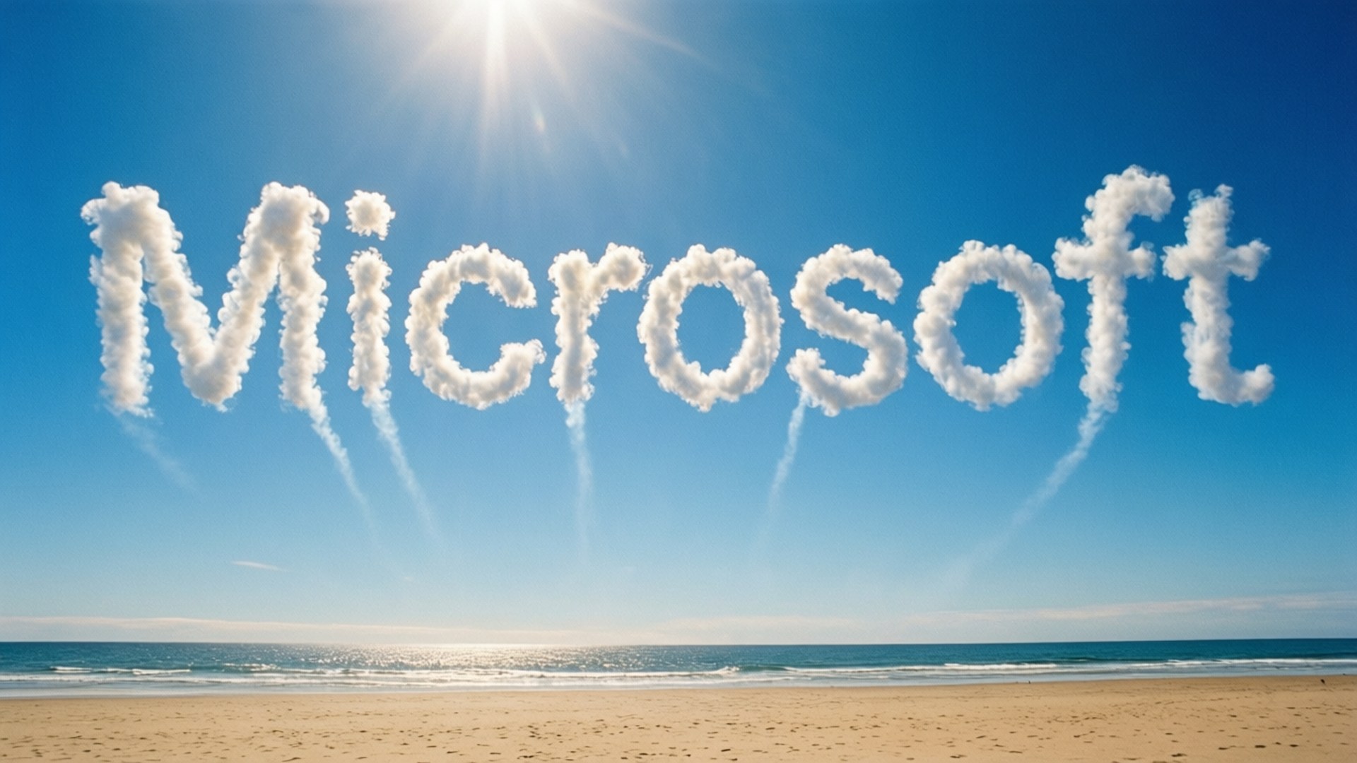 Skywriting Microsoft 壁紙 — 由 fluffy 白色雲朵組成的 Microsoft 字樣漂浮在陽光普照的海灘上，有藍綠色海洋和金色沙灘。