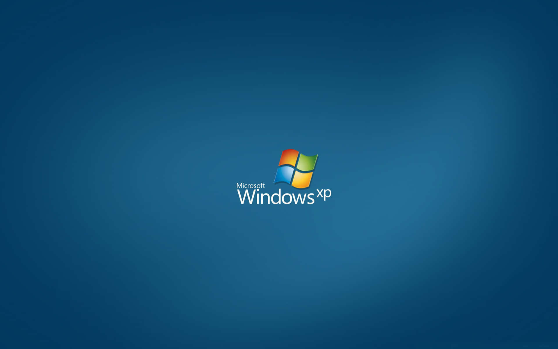  壁紙 — Microsoft Windows XP 標誌居中顯示在漸變藍色背景上，背後散發出柔和的光線。