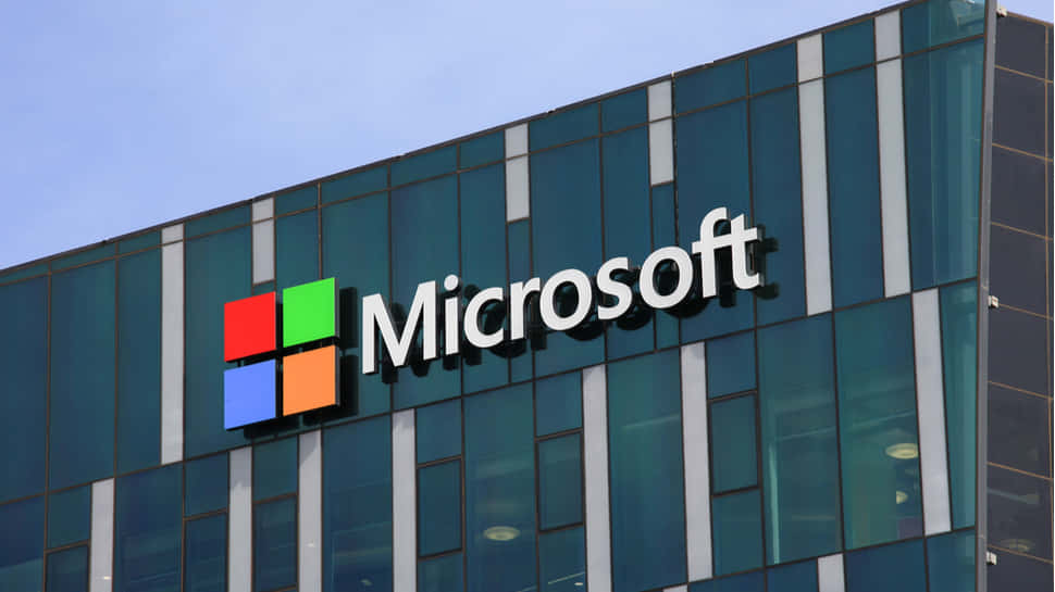 微軟企業大樓，玻璃外牆和標誌在藍天下。 — Microsoft 壁紙