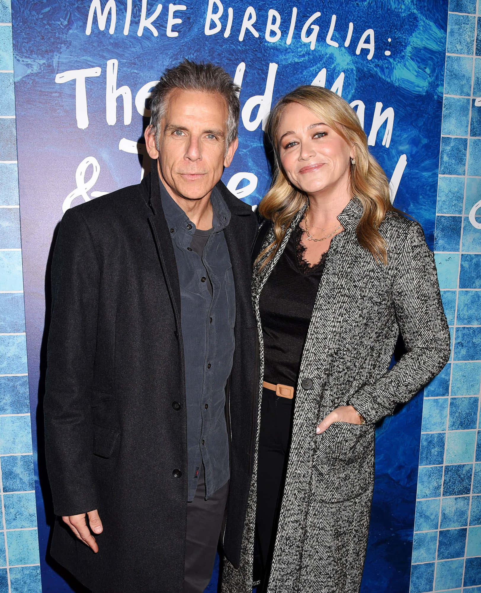 Christine Taylor 桌布 壁紙 — Mike Birbiglia 與一位女士在宣傳活動中一起擺姿勢，背景是藍色瓷磚和白色文字。