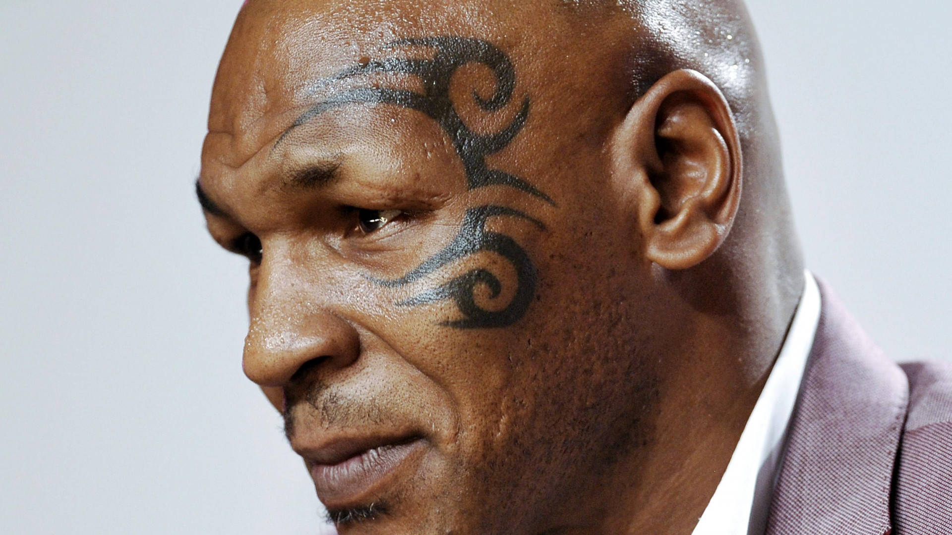 Tattoo 桌布 壁紙 — Mike Tyson 臉部特寫，展示他臉頰上標誌性的部落紋身和嚴肅表情。