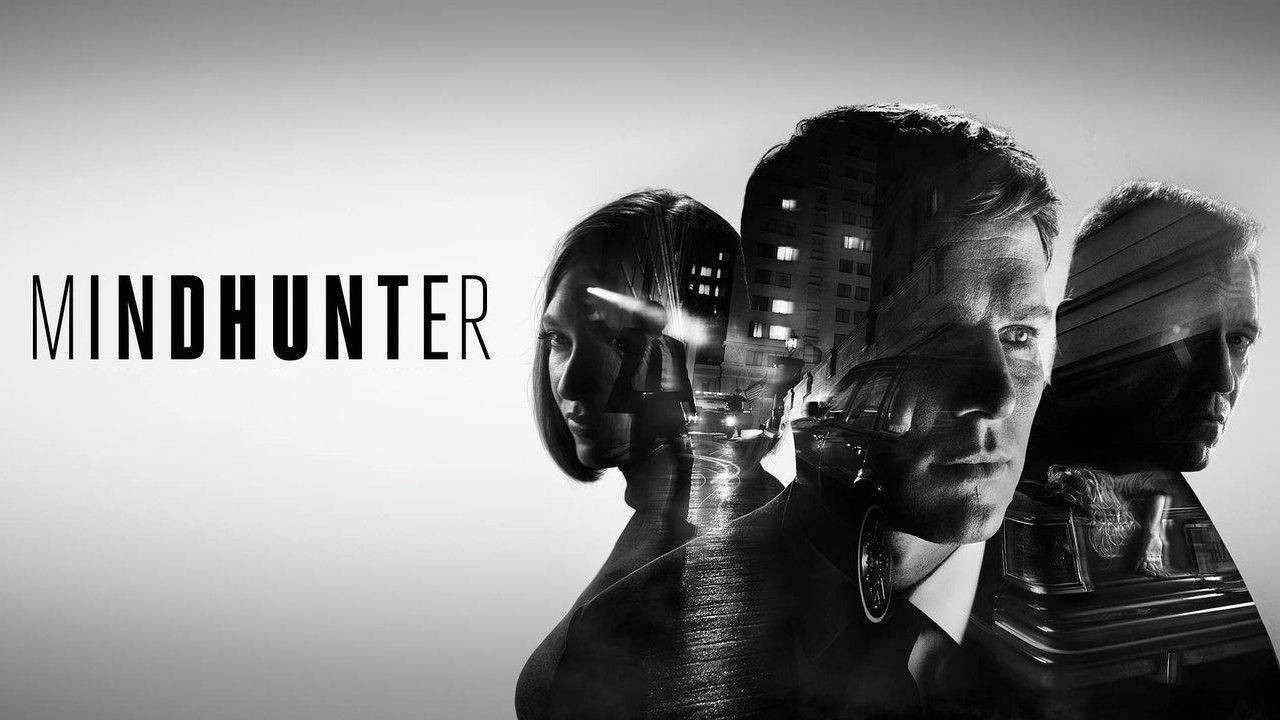 suspense 桌布 壁紙 — Mindhunter 的黑白宣傳海報，三個表情強烈的面孔疊加在夜景城市景觀上。