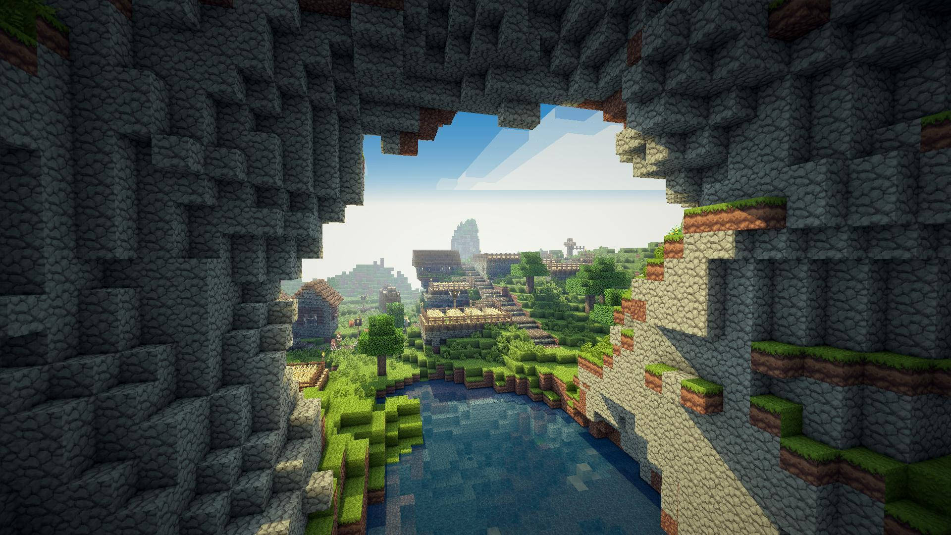 我的世界 桌布 壁紙 — Minecraft 洞穴開口揭示了一個充滿活力的像素村莊，坐落在河邊，天空明亮。