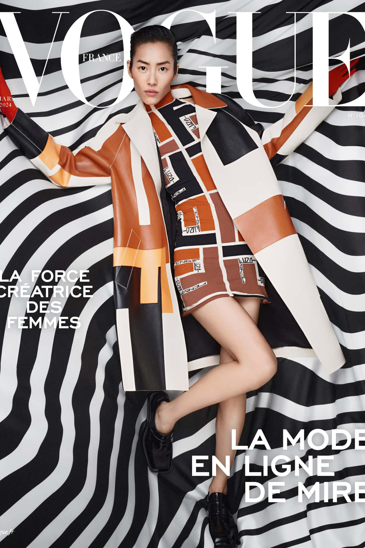  壁紙 — 一位模特兒穿著大膽的幾何圖案外套，在Vogue France雜誌封面上，自信地擺姿勢，背景是黑白波浪條紋。