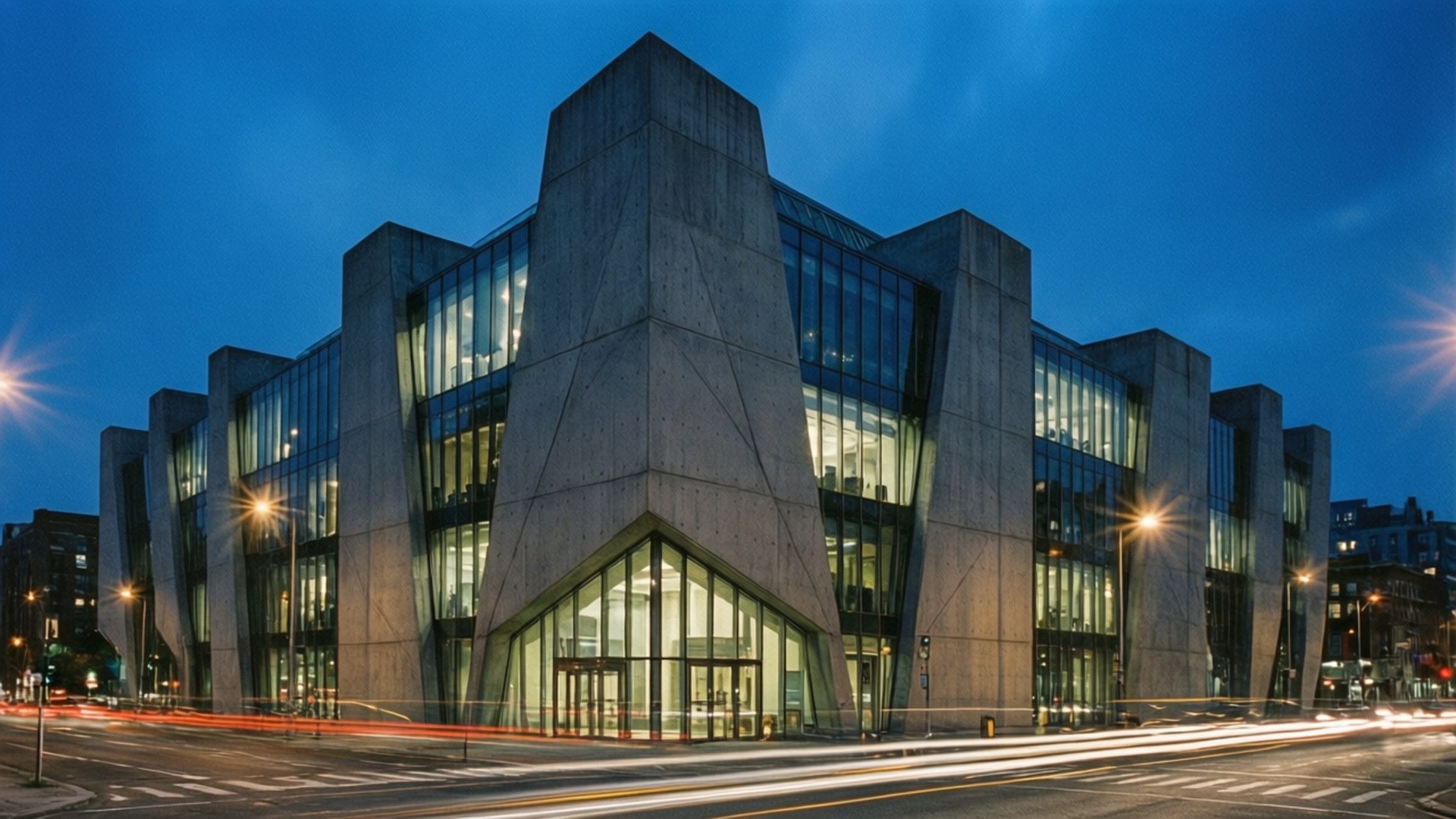Modern Architecture Night 壁紙 — 一座現代混凝土和玻璃建築在黃昏時發光，下方有城市交通燈光的痕跡。
