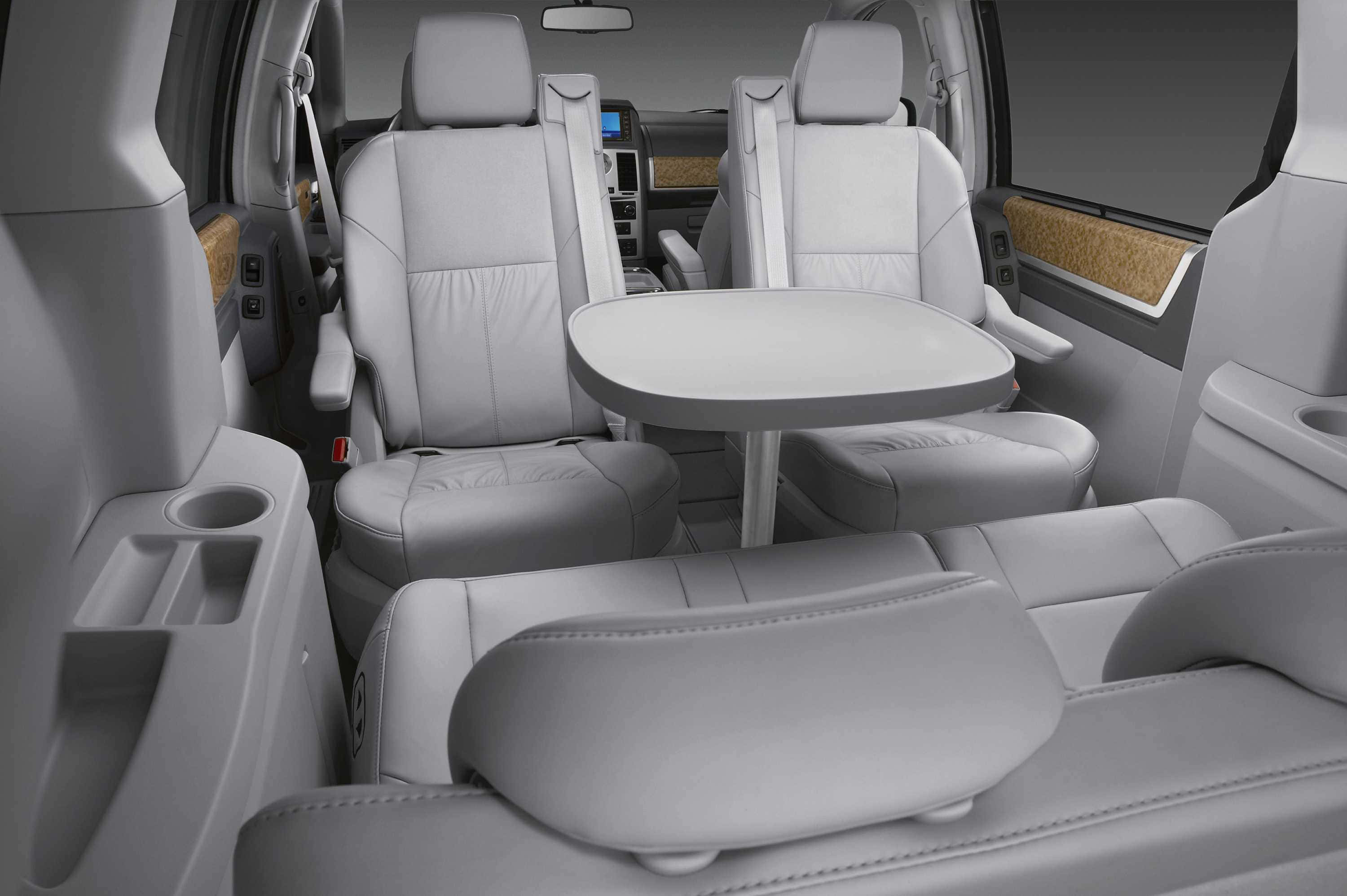 Chrysler Voyager 桌布 壁紙 — 現代小型貨車內部，配有淺灰色皮革座椅和後排乘客用的折疊桌。