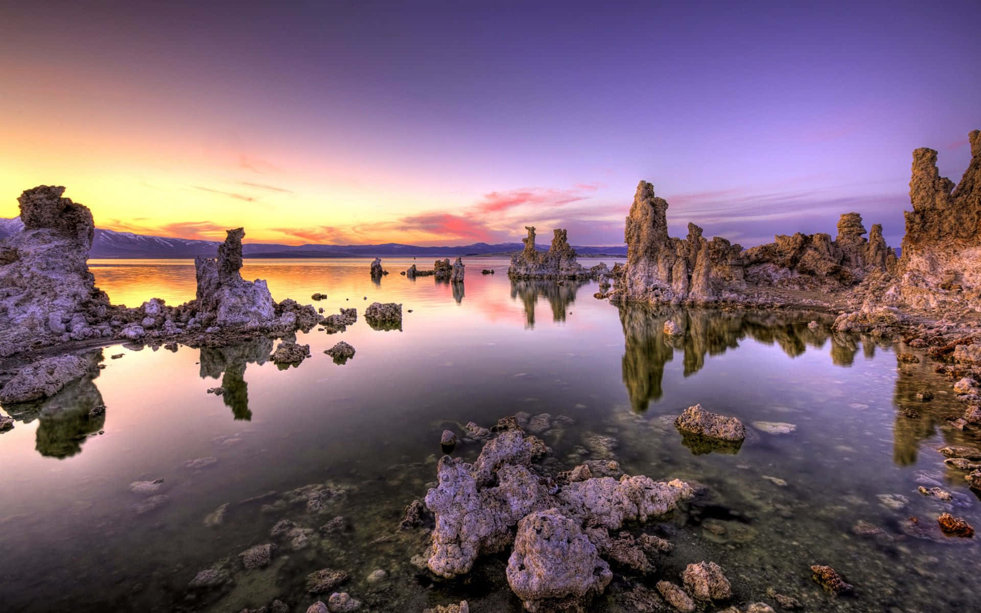 Israel 桌布 壁紙 — Mono Lake 上壯觀的日出，超現實的凝灰岩塔在平靜的水面上倒映，天空呈現漸變的紫色和橙色。