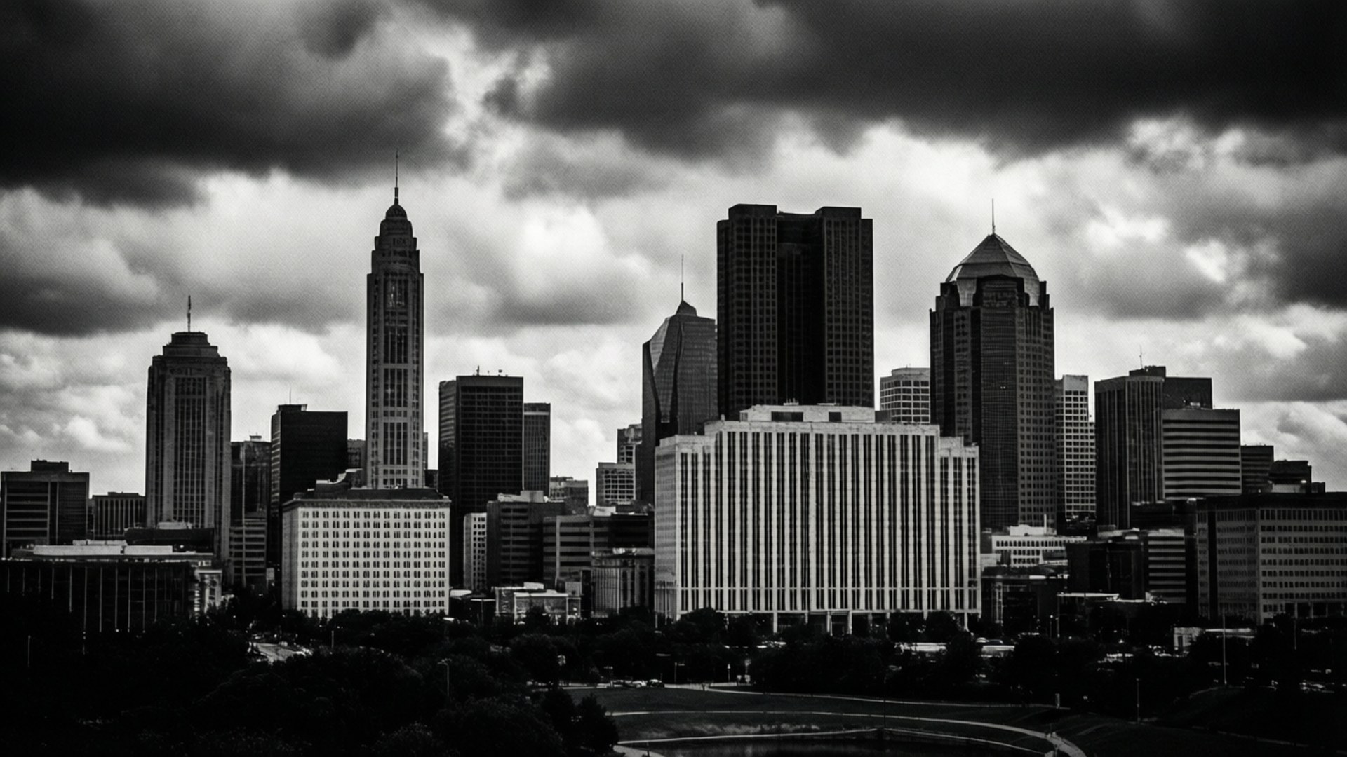 Monochrome OKC Skyline 壁紙 — 單色城市天際線，高聳的摩天大樓在戲劇性的暴風雲下。