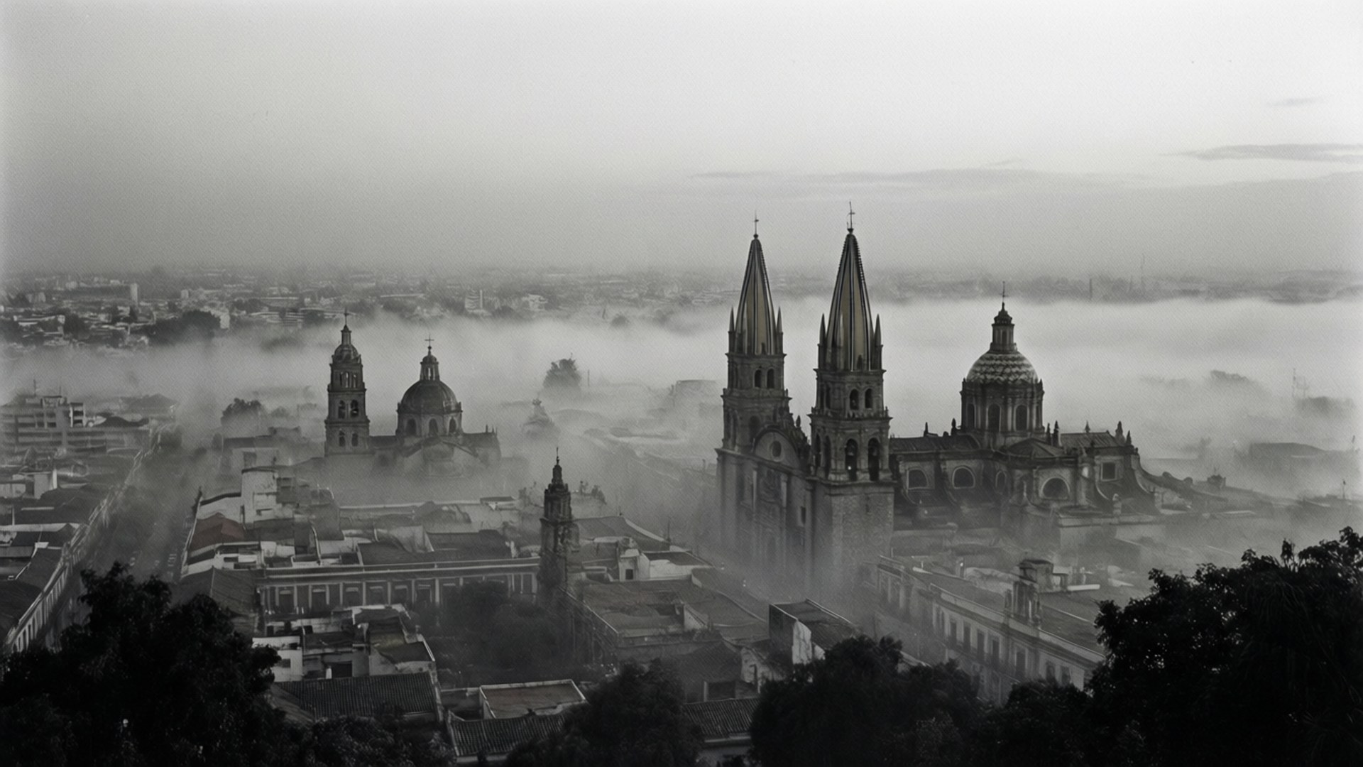 Fog Over Guadalajara 壁紙 — 城市景觀的單色視圖，高聳的大教堂穿透厚厚的霧毯。