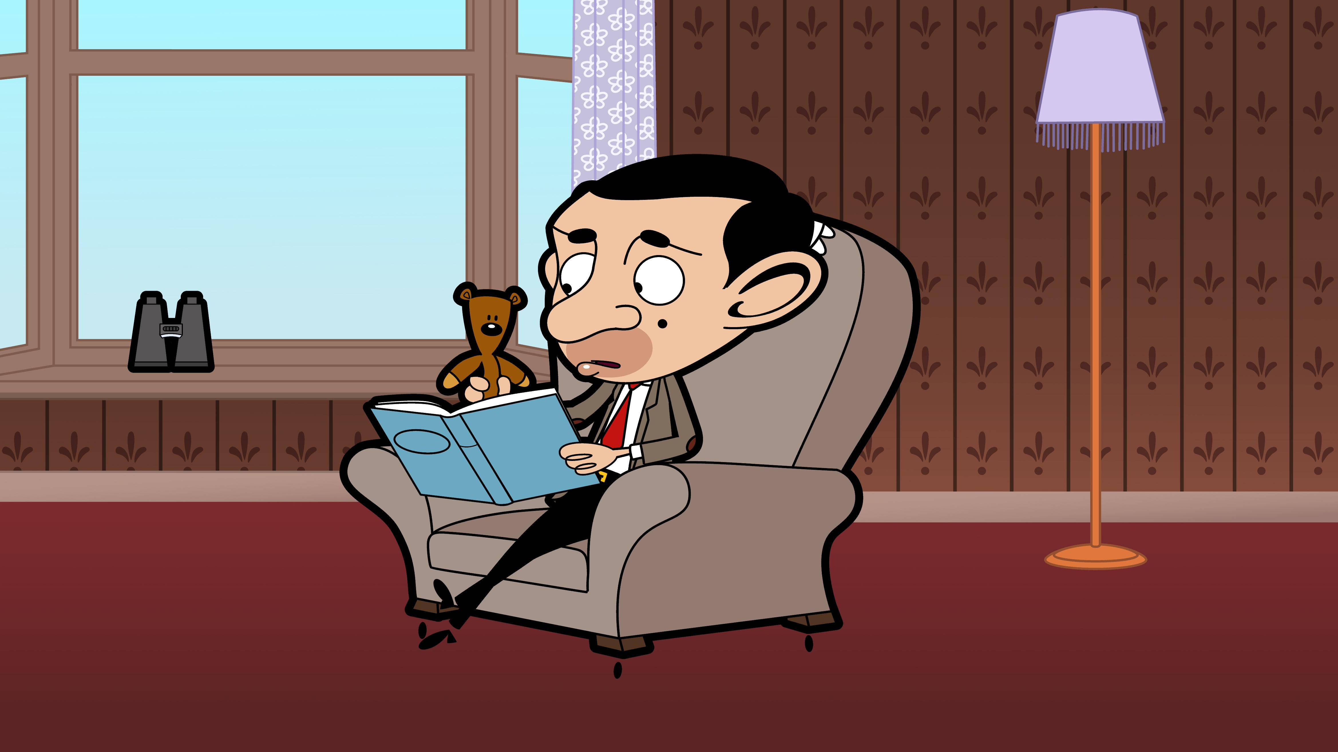 4K 桌布 壁紙 — Mr Bean 坐在一張棕色扶手椅上，讀著一本藍色書，旁邊有一隻泰迪熊，房間貼有圖案壁紙。