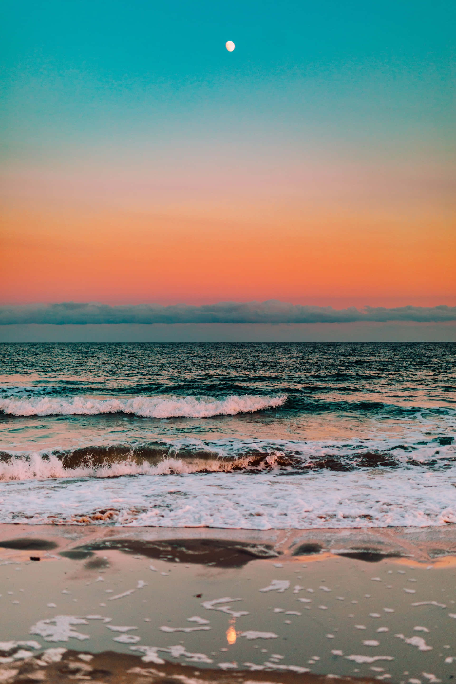 Colorful Sunset 桌布 壁紙 — 暮色中寧靜的海灘，在青綠、橙和粉紅漸變的天空下，溫柔的海浪拍打著，明亮的月亮高掛。