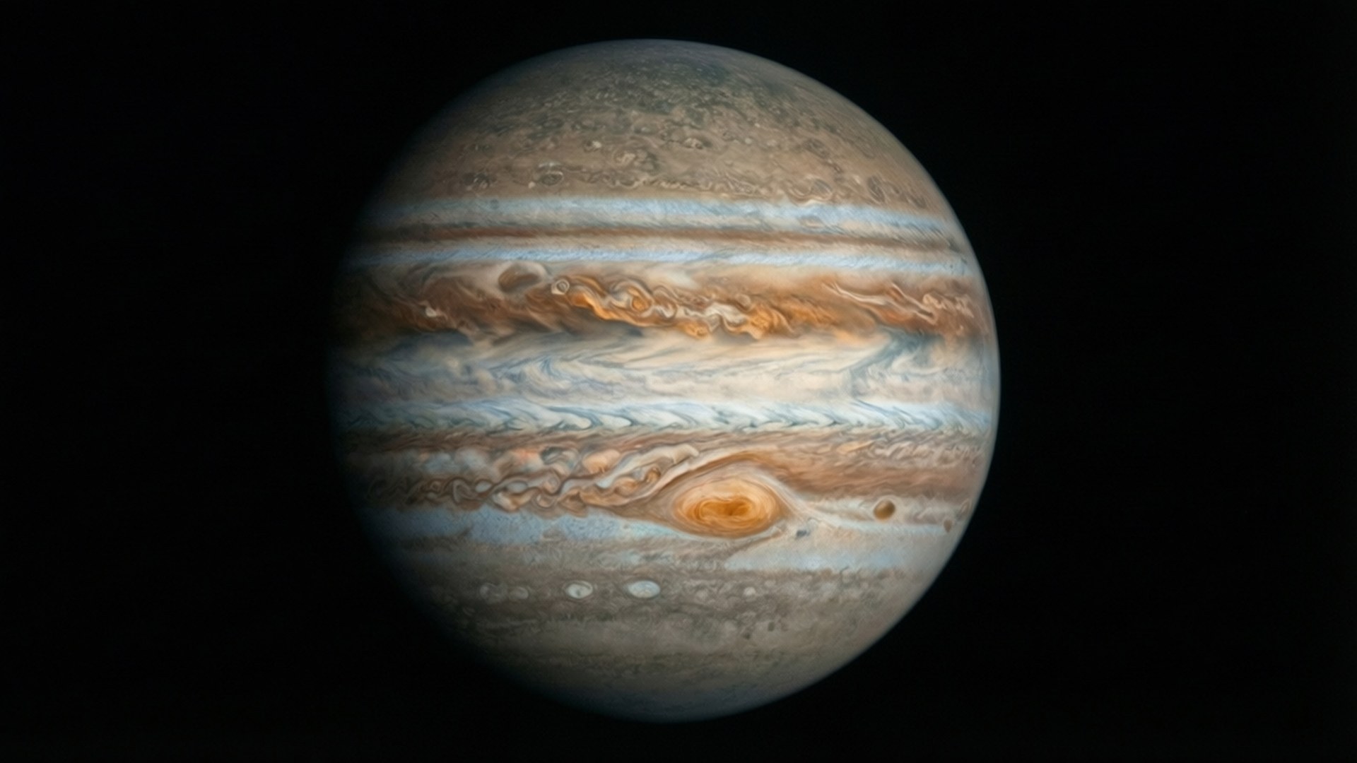 Full Disc Jupiter 壁紙 — 木星主導整個畫面，呈現出米色、棕色和白色雲層的漩渦帶，以及一個突出的橙紅色大紅斑，背景是黑色虛空。