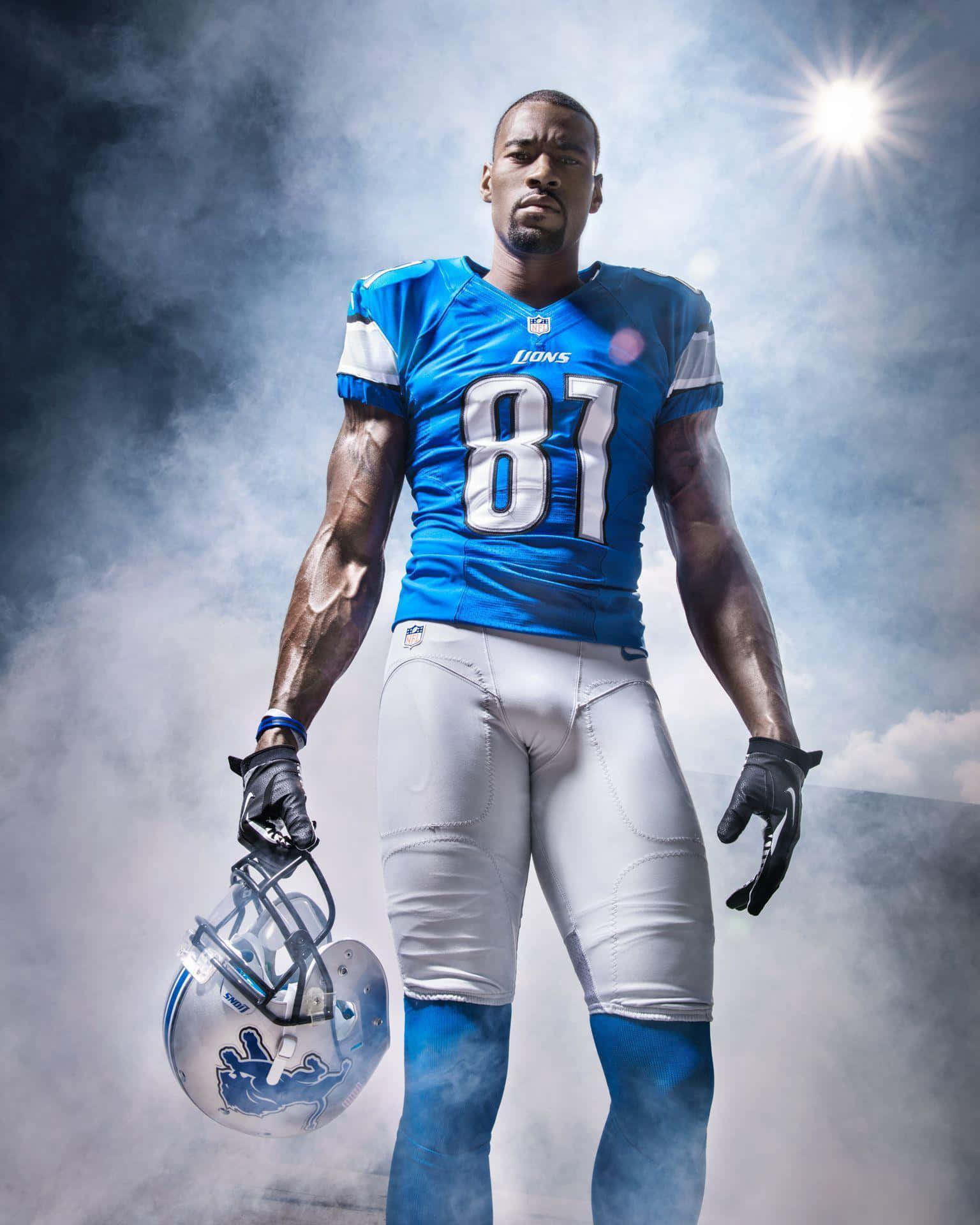  壁紙 — 一位肌肉發達的NFL球員身穿藍色獅子隊球衣，自信地站在煙霧繚繞的背景前，手持頭盔，背後有明亮的陽光四射。