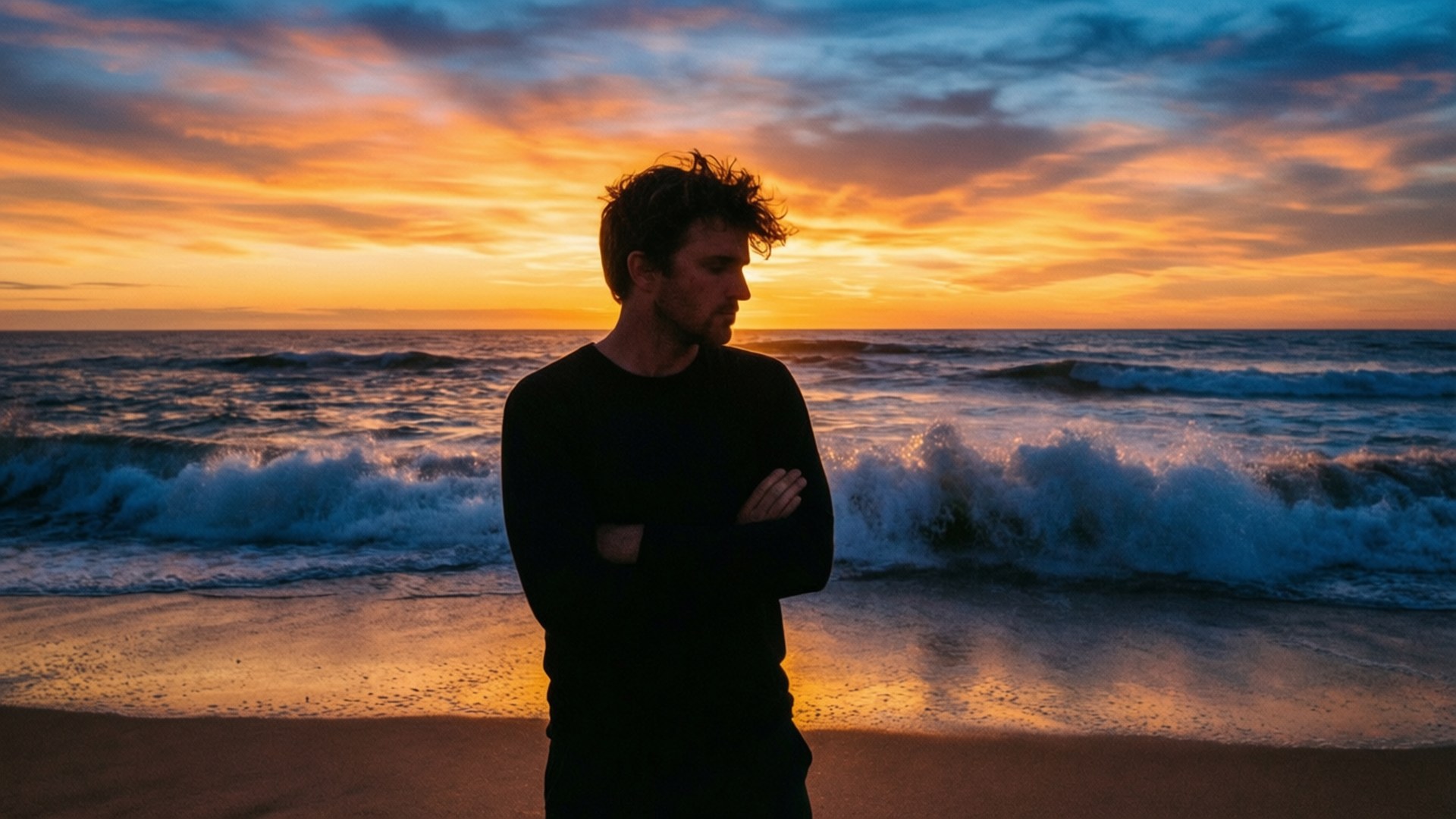 Beach Sunset Contemplation 壁紙 — 一個男人站在海灘上，在火紅的日落天空下，海浪拍打著，形成剪影。