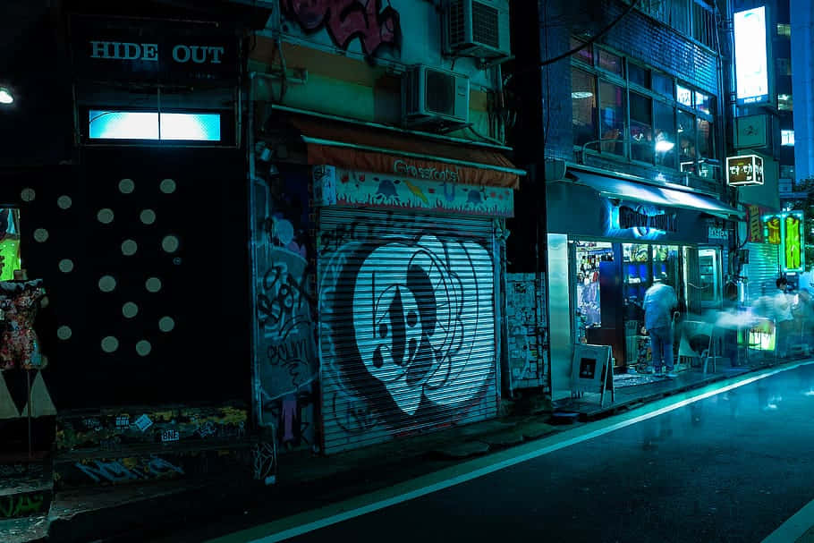  壁紙 — 夜晚霓虹燈照亮的城市小巷，塗鴉覆蓋的百葉窗和潮濕的路面反射著發光的招牌。