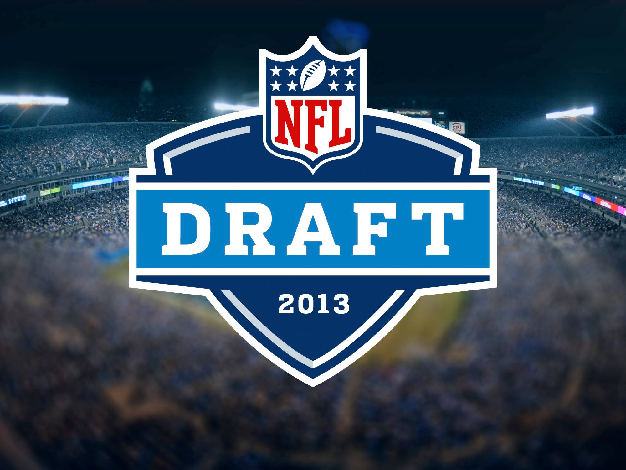 酷炫足球 桌布 壁紙 — NFL Draft 2013 標誌突出顯示在一個模糊的夜間體育場上，場內擠滿了歡呼的球迷。