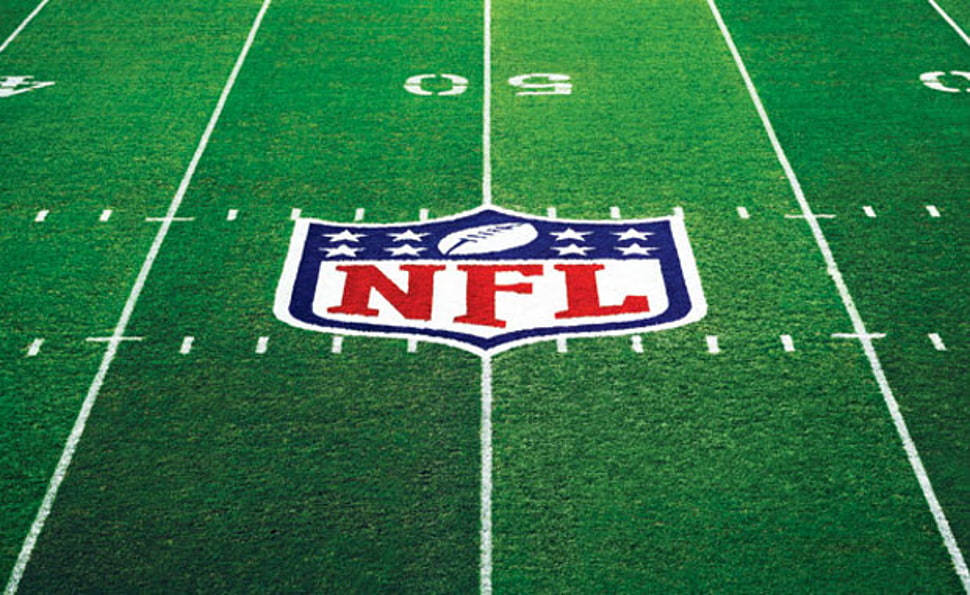 Cool NFL 桌布 壁紙 — NFL 標誌的特寫視圖，位於充滿活力的綠色足球場中央，帶有清晰的白線。