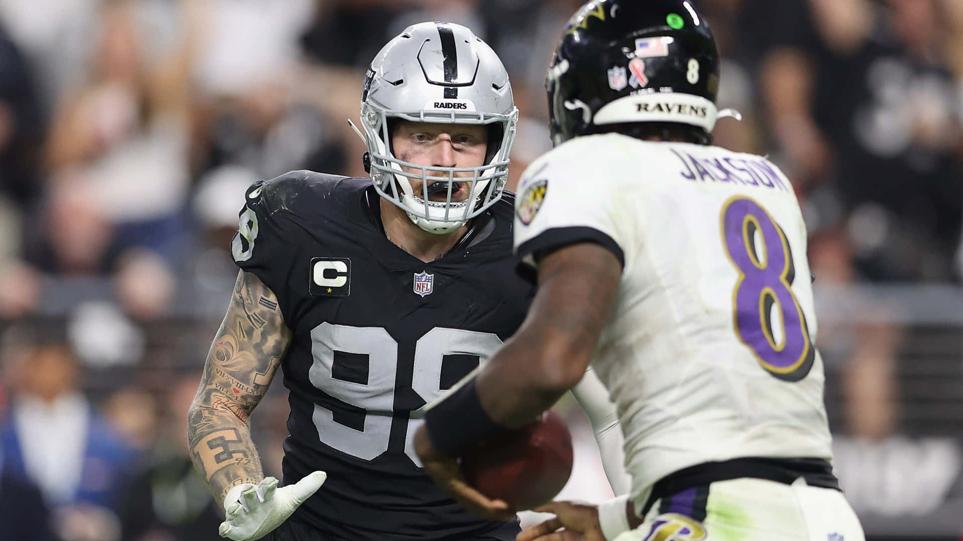 NFL線衛與四分衛在夜間比賽中行動。 — 巴爾的摩烏鴉隊 GIF 壁紙