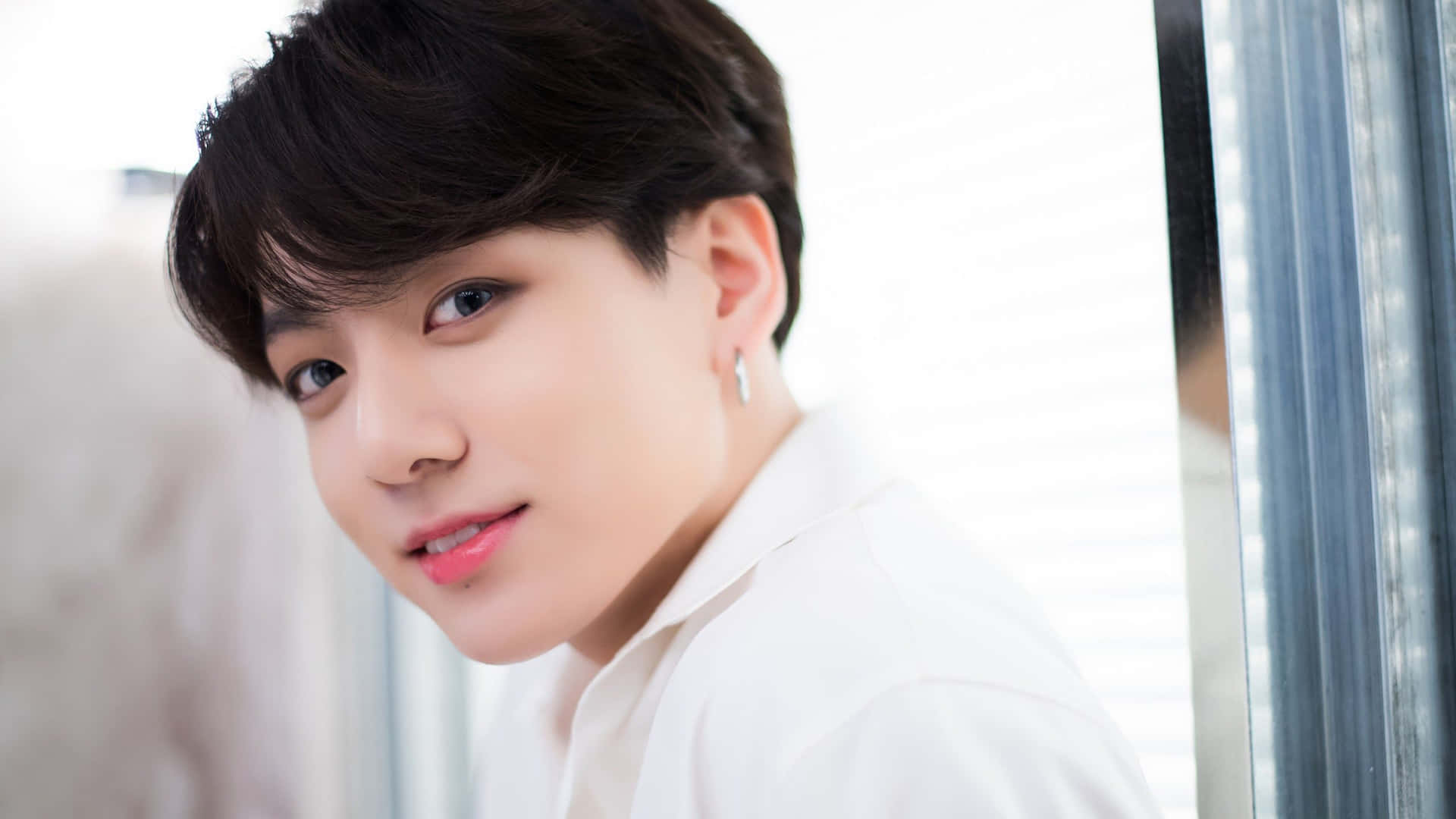 身穿白襯衫的年輕男子在百葉窗旁微笑 — Jungkook 壁紙