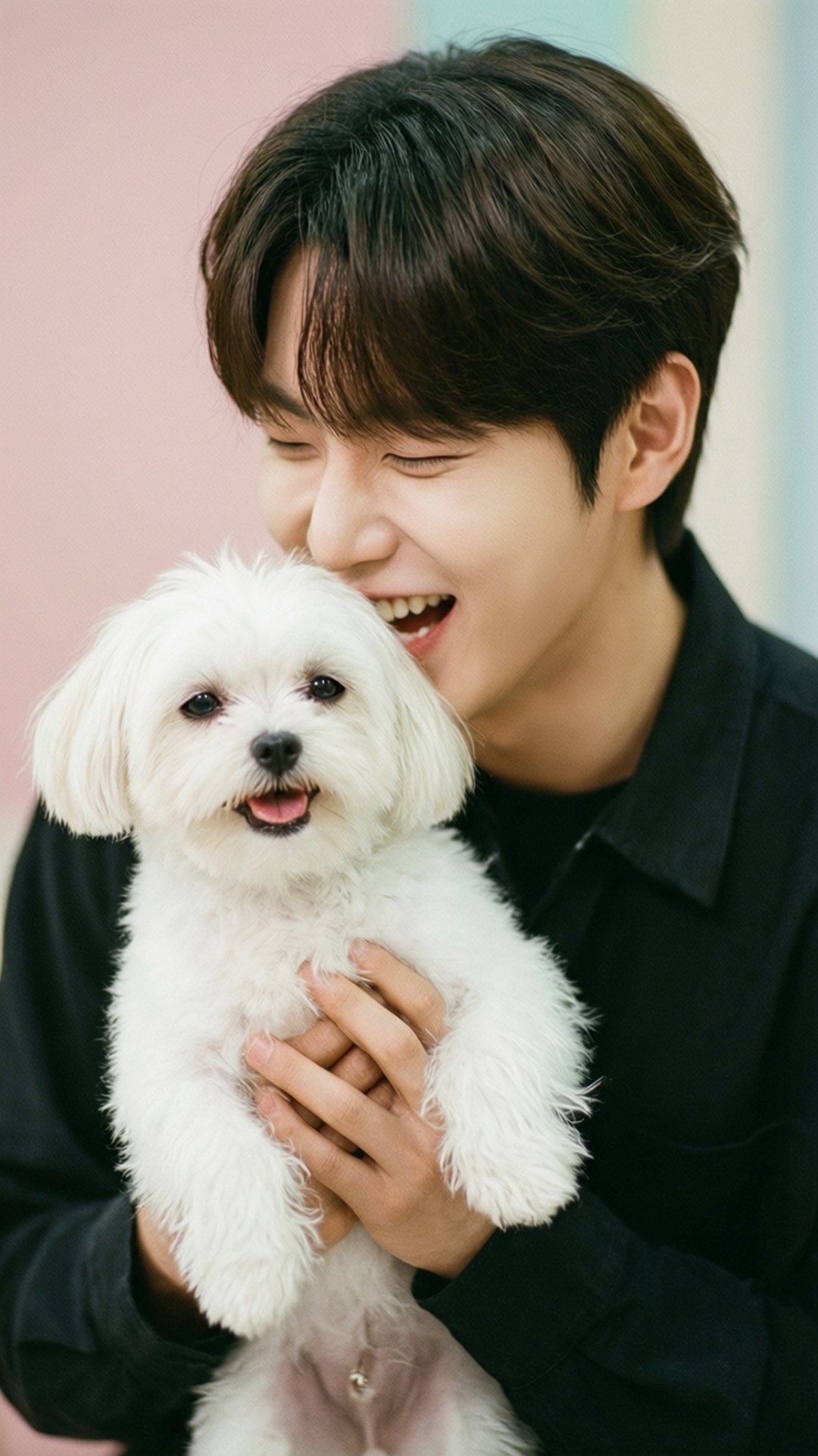 Jeonghan and Puppy 壁紙 — 一名身穿黑色襯衫的年輕男子，在柔和的粉紅色和藍綠色背景前，懷抱一隻毛茸茸的白色小狗，滿臉喜悅。