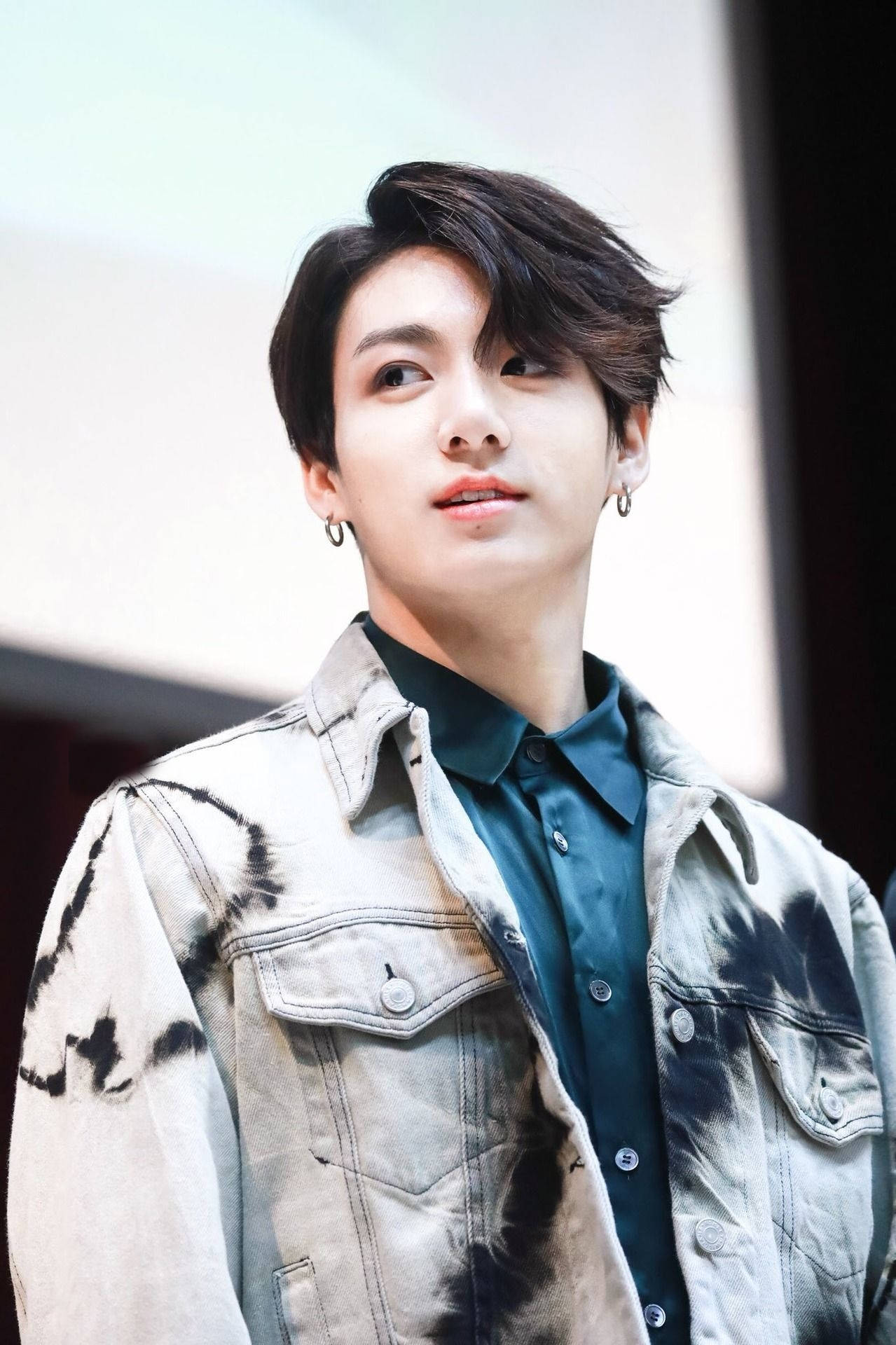年輕男子身穿紮染牛仔外套和深色襯衫向上仰望 — Bts 壁紙