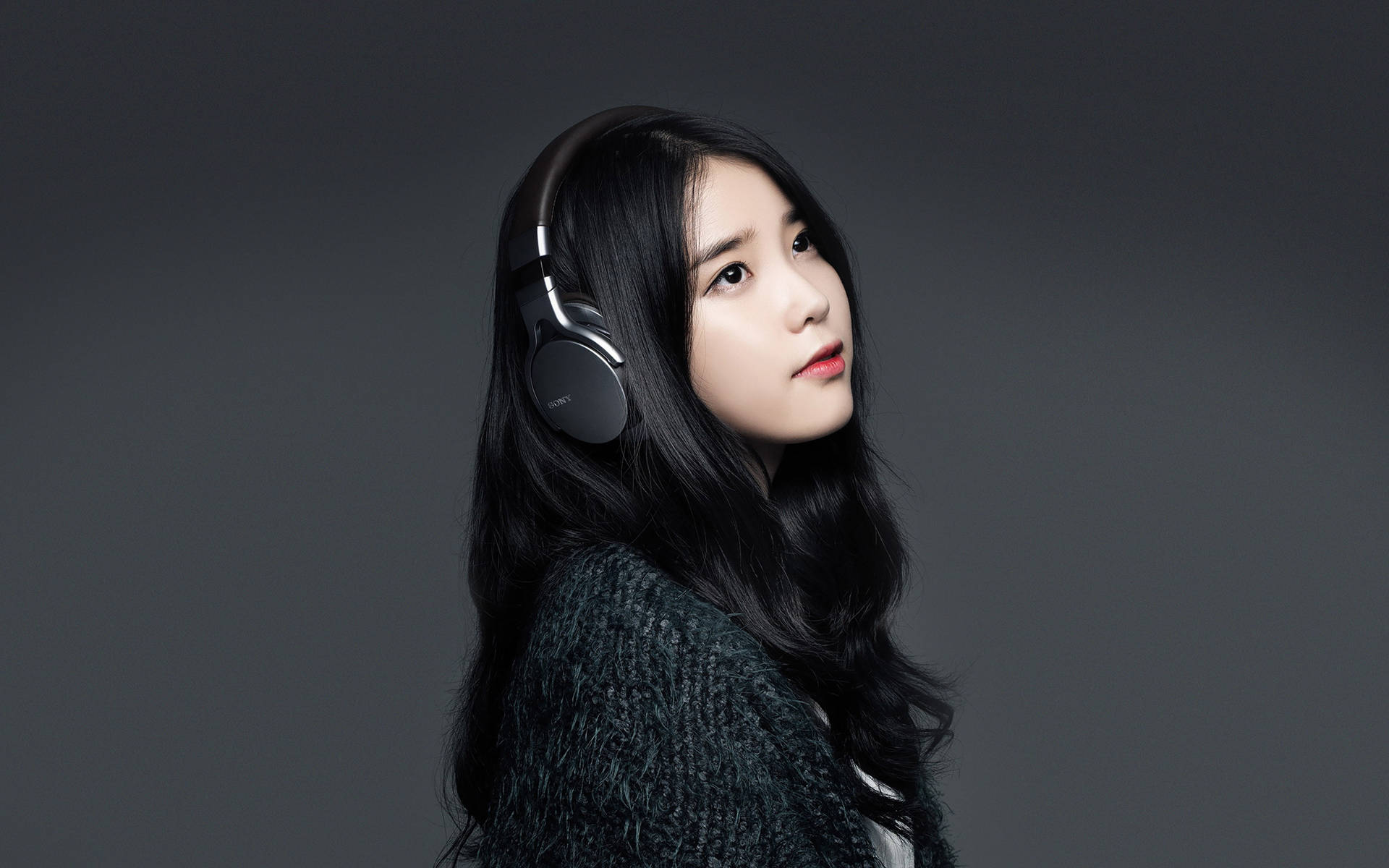 年輕女性在攝影棚中戴著頭戴式耳機 — K Pop 壁紙
