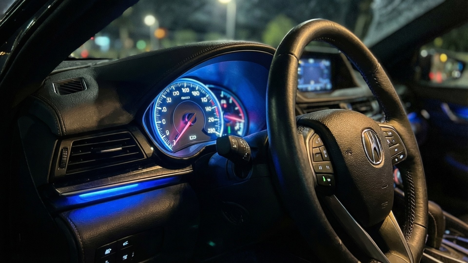 Blue Ambient TLX 壁紙 — 夜間車內，藍色發光儀表板和方向盤，城市燈光下。
