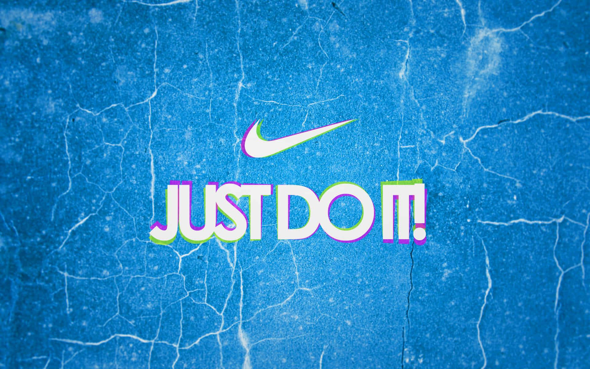 Nike 桌布 壁紙 — Nike 標誌性的「Just Do It!」口號以粗體彩色字體呈現在裂紋藍色紋理背景上。