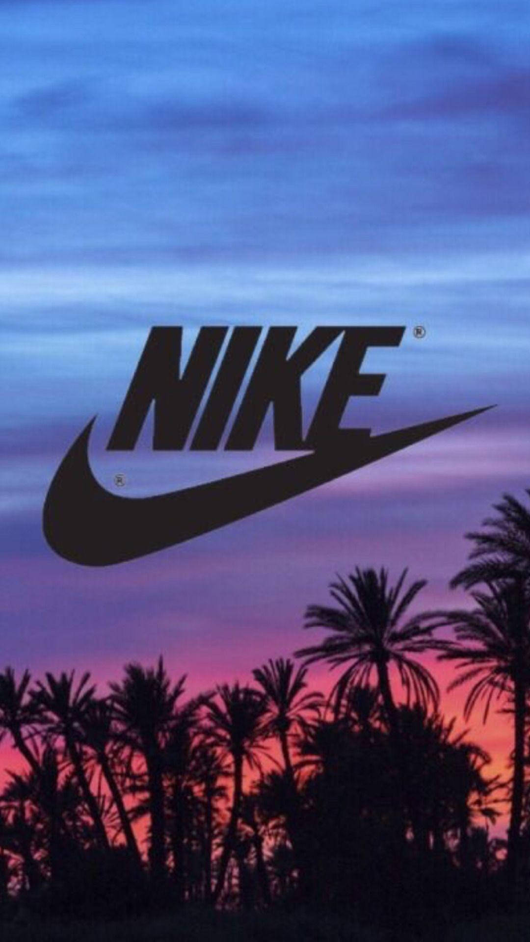 Nike iPhone 桌布 壁紙 — Nike 標誌漂浮在棕櫚樹剪影之上，背景是充滿活力的紫色和橙色日落天空。