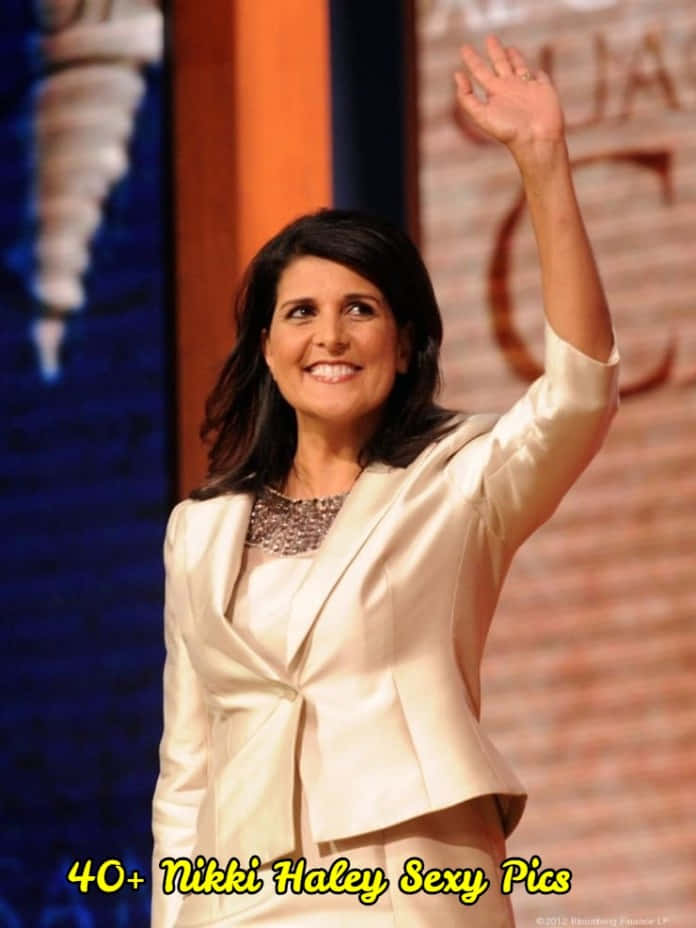 政治 桌布 壁紙 — Nikki Haley 身穿米色西裝外套，在磚牆和藍色背景下熱情揮手。