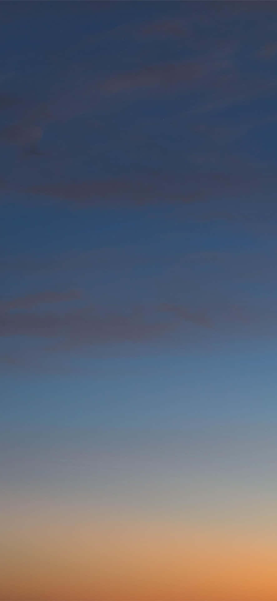  壁紙 — 寧靜的黃昏天空，從深藍色過渡到地平線附近的暖橙色，帶有柔和縷縷雲彩。